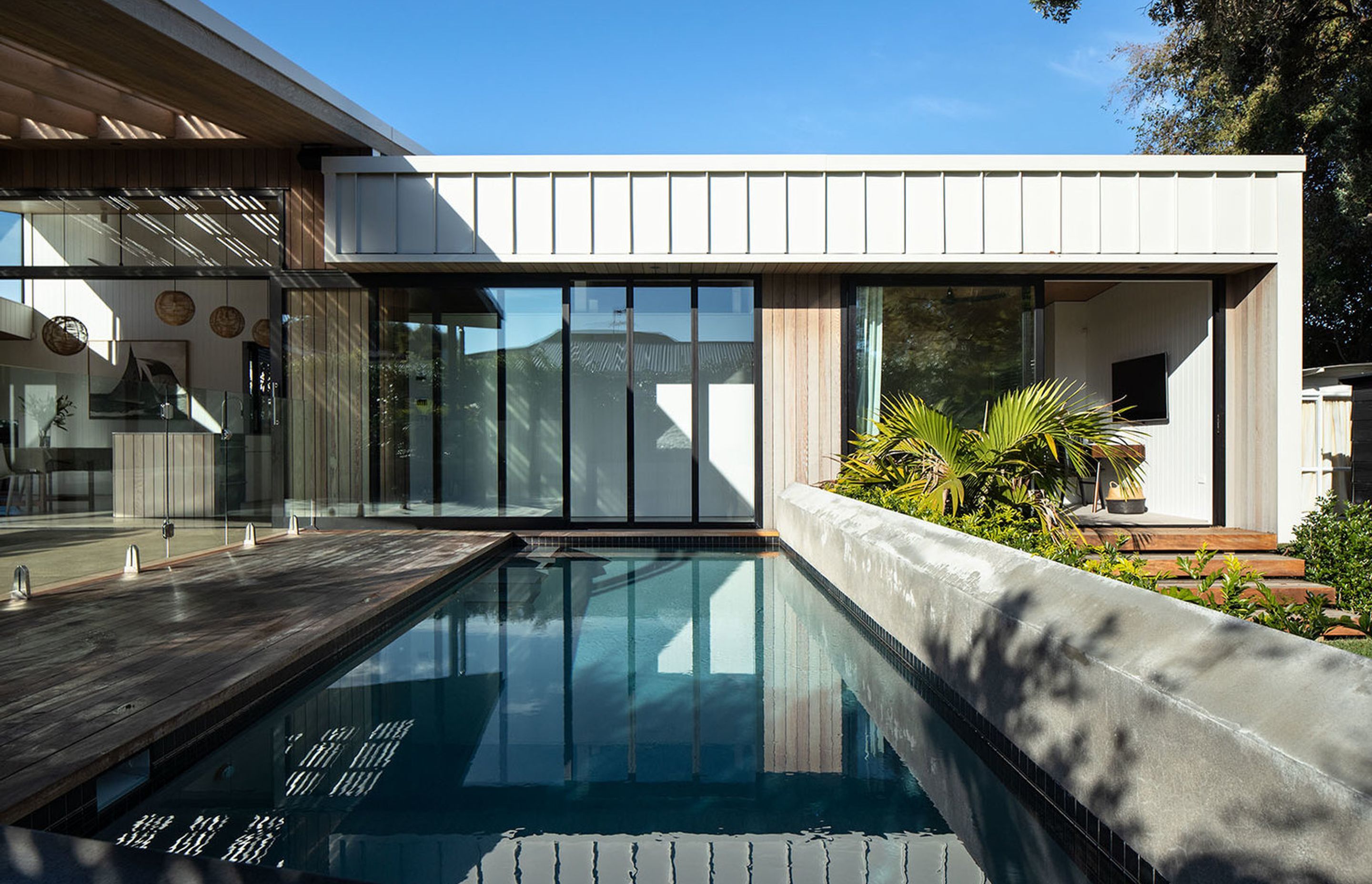 The bedrooms are recessed under the eaves to help control the entry of sunlight, while reflected watery patterns are cast onto the interior surfaces from the pool.