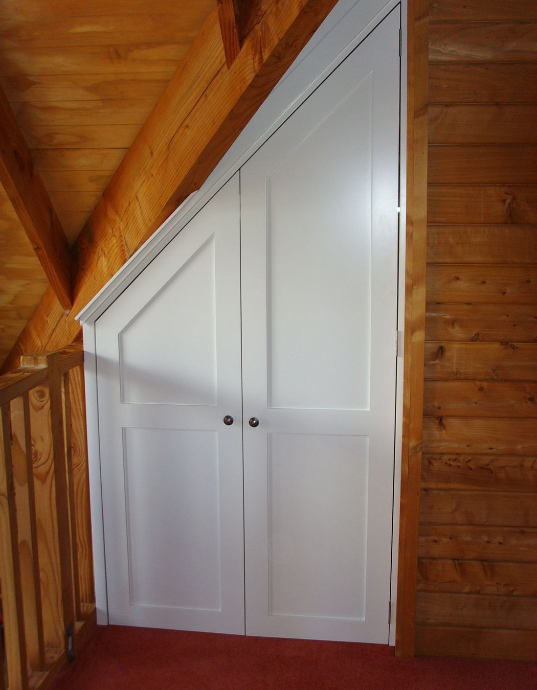 Storage cupboard in-built under roof eaves.