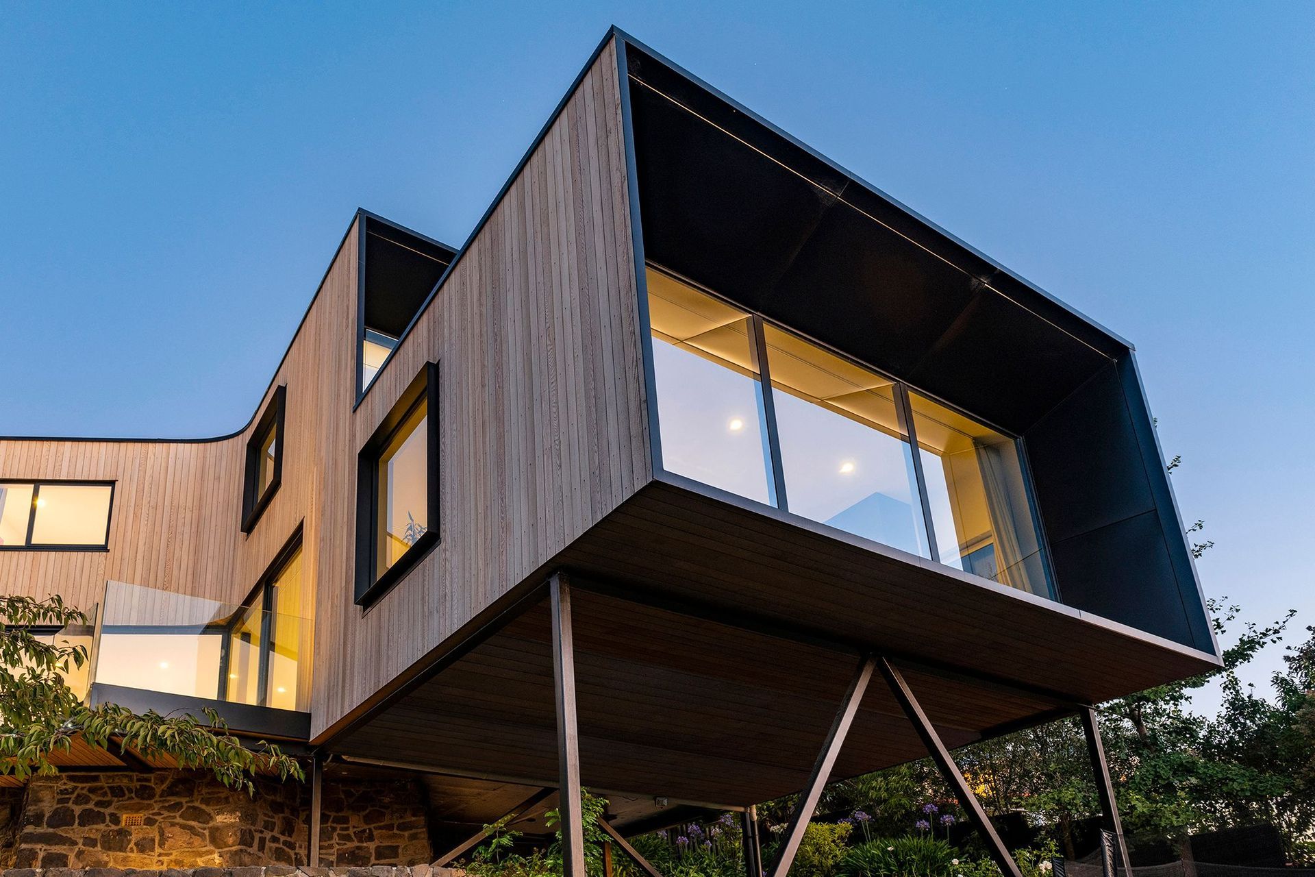 CoLab's light cedar-clad form is perched on slender steel stilts over the historic foundations of one of Christchurch's most influential architects, Samuel Hurst Seager.