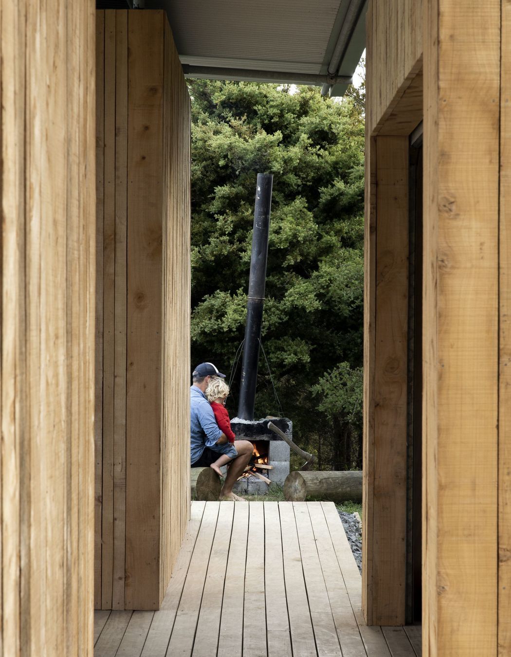 The owner, Simon Wilson, with his son building a fire in the fireplace he built himself.