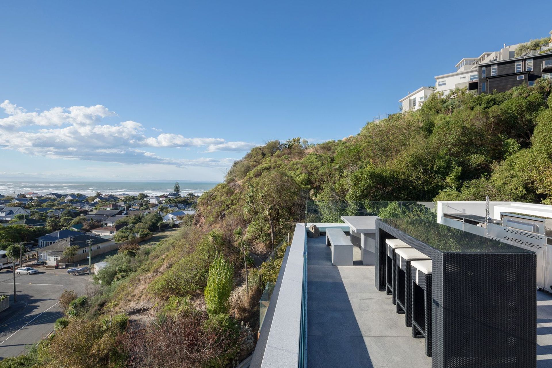 The outdoor kitchen and dining area on the roof terrace, surrounded by mostly native landscaping in its infancy, designed by Kamo Marsh.
