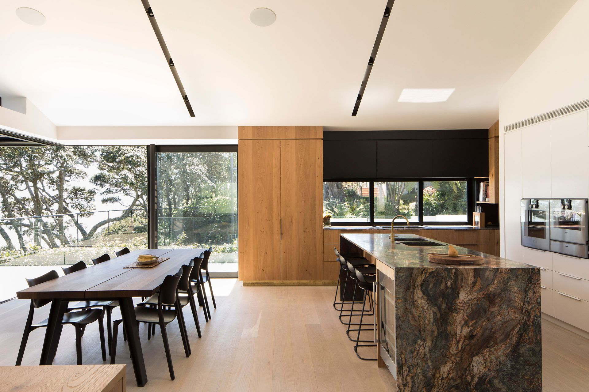 The kitchen enjoys a views of the neighbours tennis court and across the living space to the ocean.