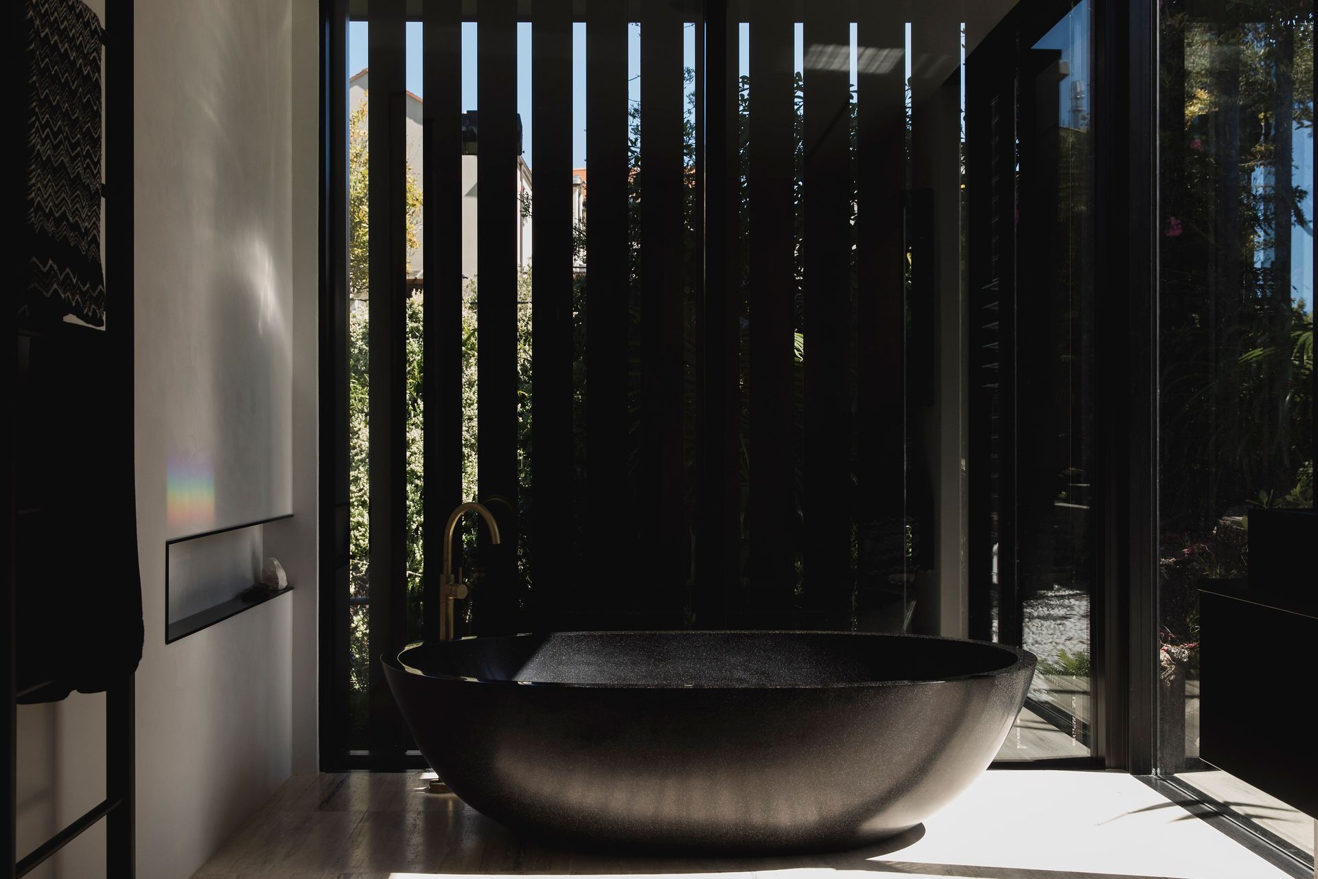 The architects really love designing bathrooms that are really intenses spaces, including this en suite bathroom with curvaceous freestanding black bath.
