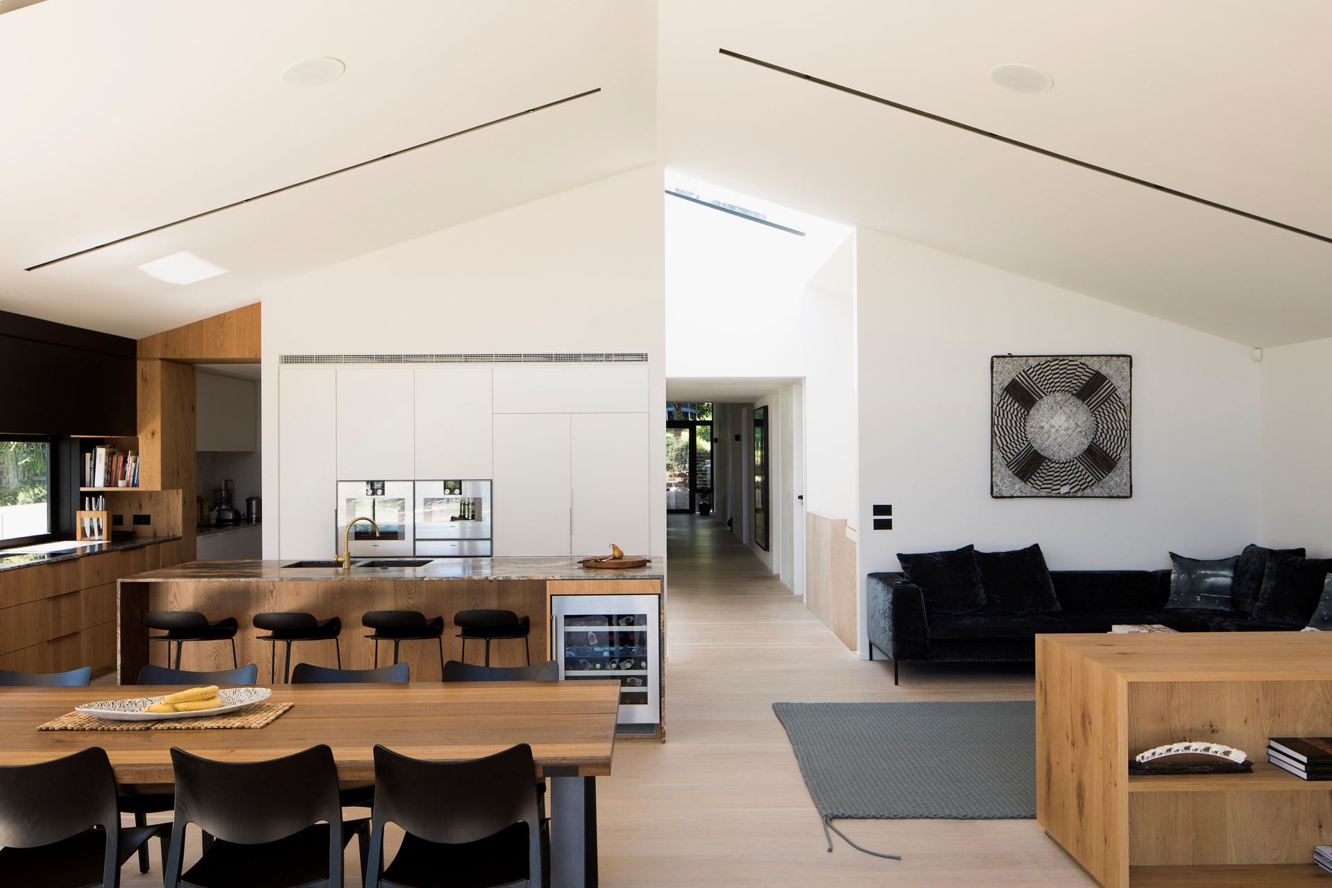 The open-plan living, dining and kitchen space leading to a scullery on the left and the central corridor just off the central axis.