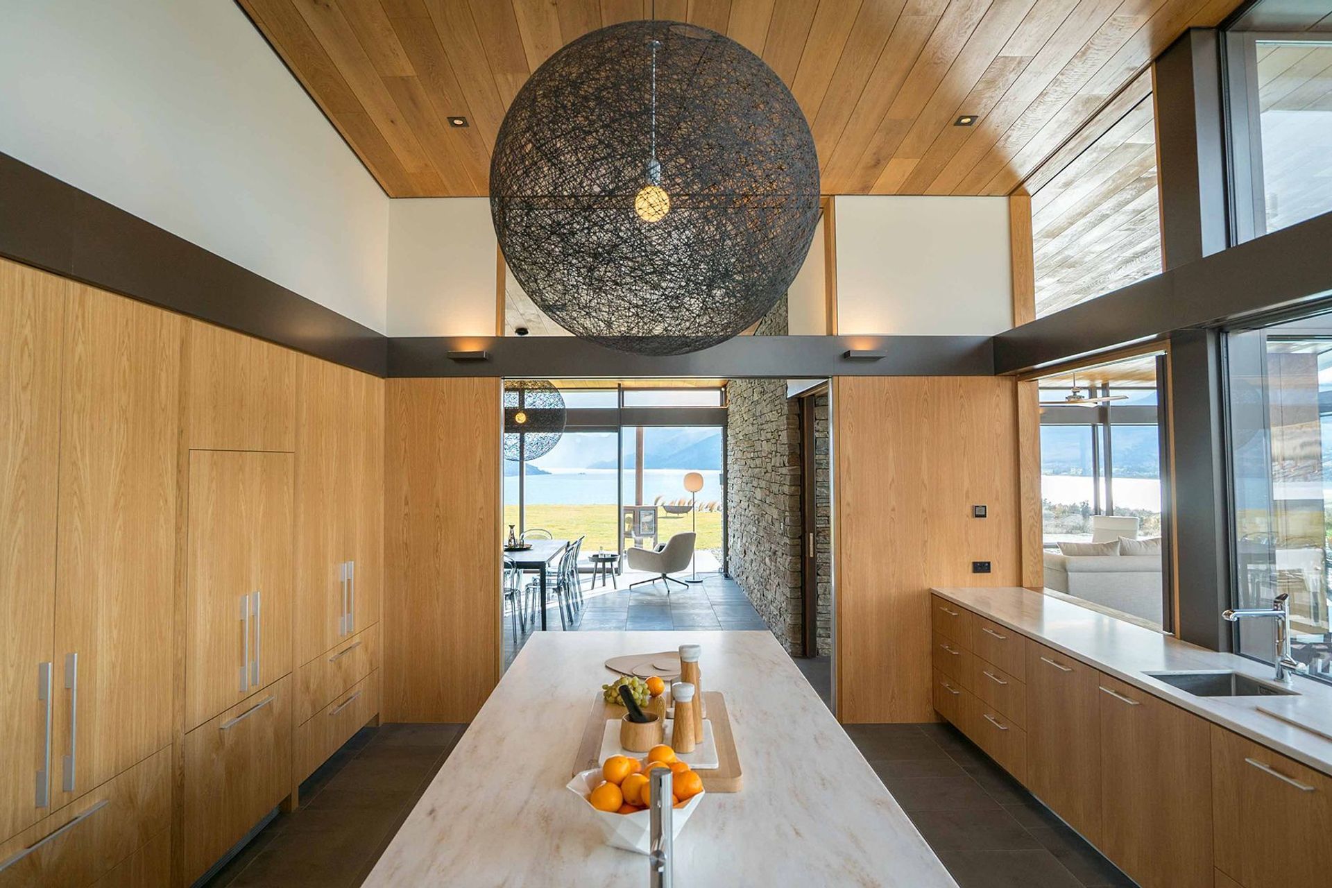 The kitchen joinery features engineered American oak, stained with coffee and natural oil, and an island with a light-coloured Corian top. Photograph: ArchiPro.