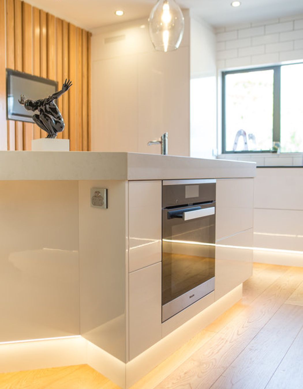 The kitchen is not unlike a commercial kitchen set up with a central prep bench, hot line behind and prep sink adjacent.