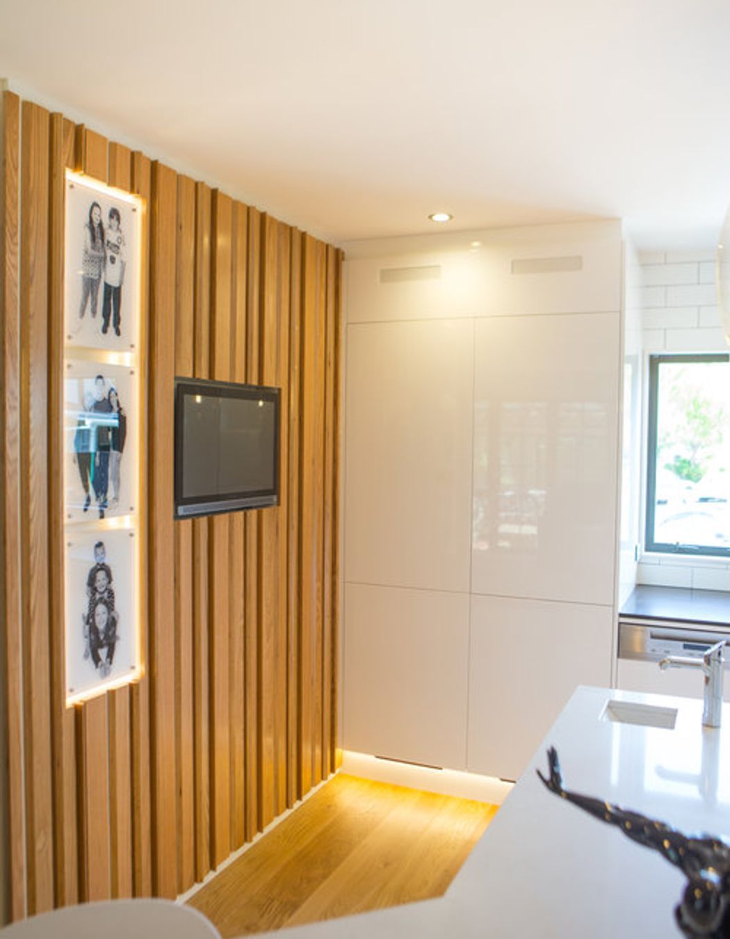 This was a unique response to the client’s brief - an oak plywood slatted divider wall, which brings the family’s personality to the space through an inset touch screen computer and digital photo frames.