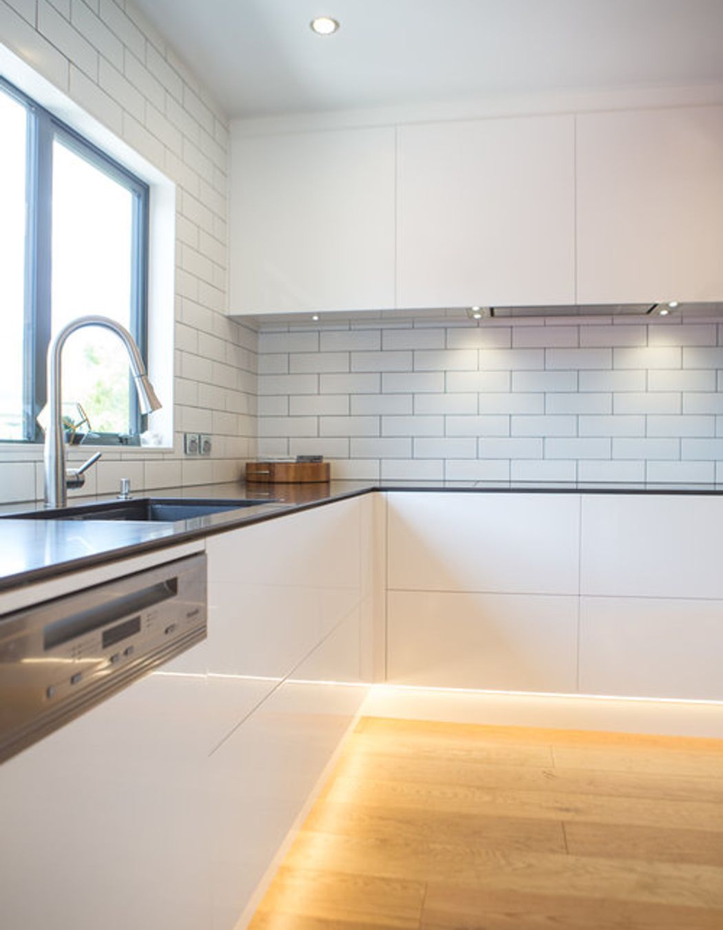 Clean lines, slim Caesarstone benchtops and handleless gloss cabinetry.