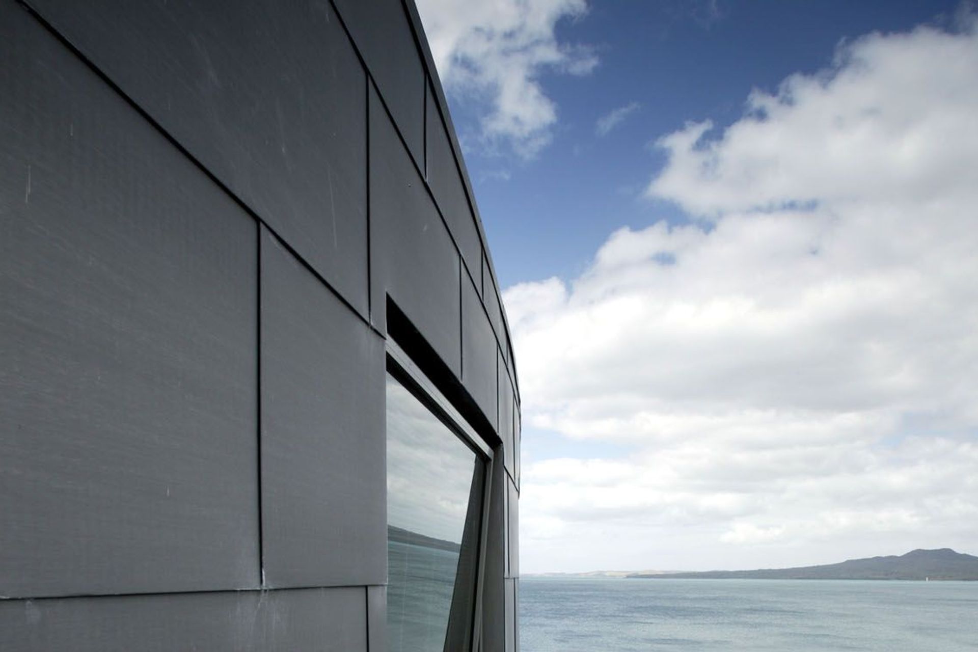 Curved zinc cladding of upper level looking towards Rangitoto Island