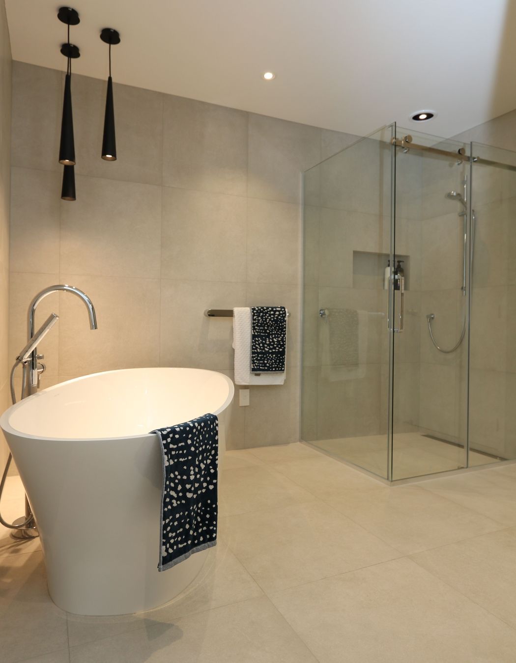 The main bathroom exerts just as much wow-factor as the ensuite with its large frameless glass shower and luxurious bath set-up.