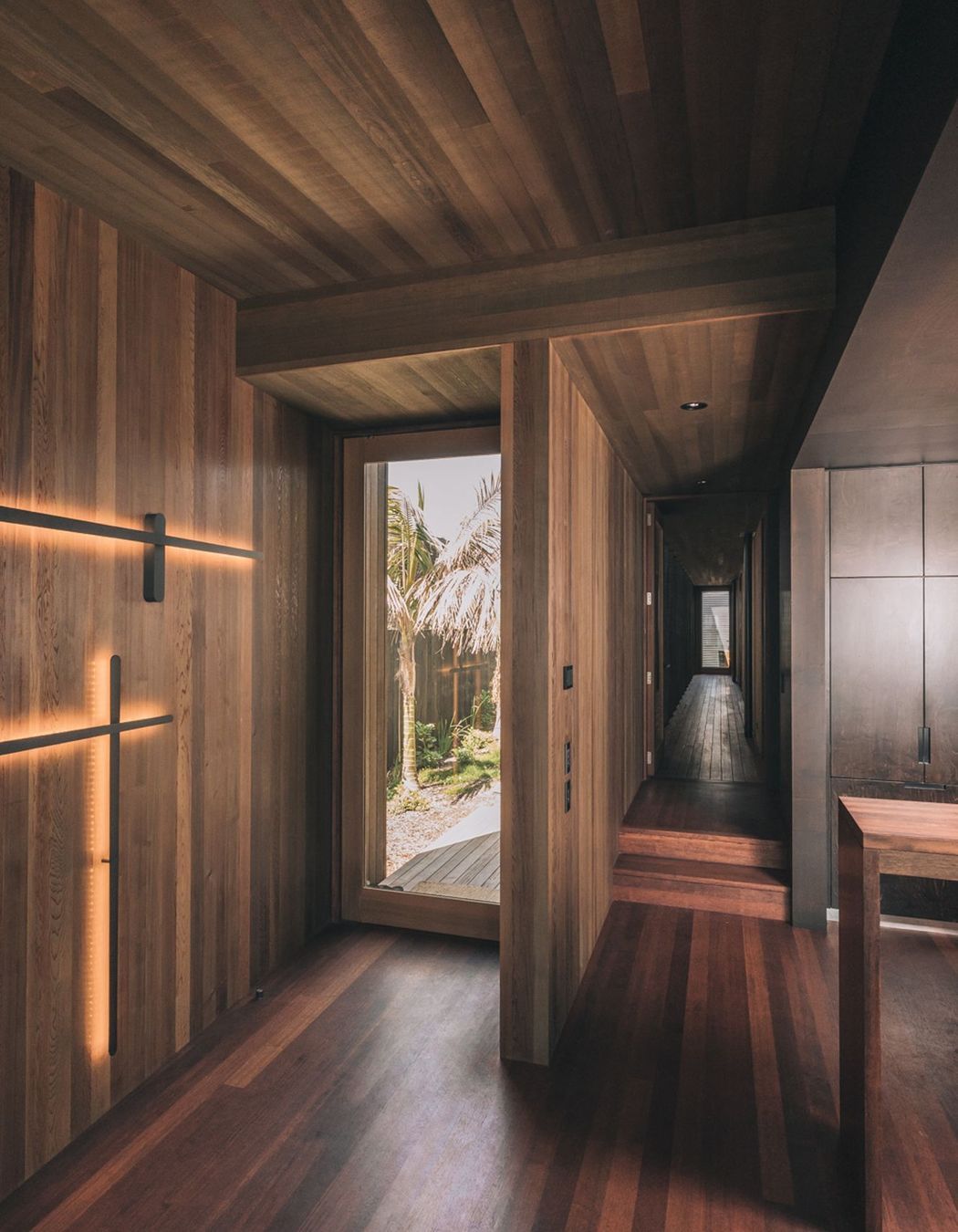 The interiors are dominanted by rich timber and deep tones, unusual for beachside homes.