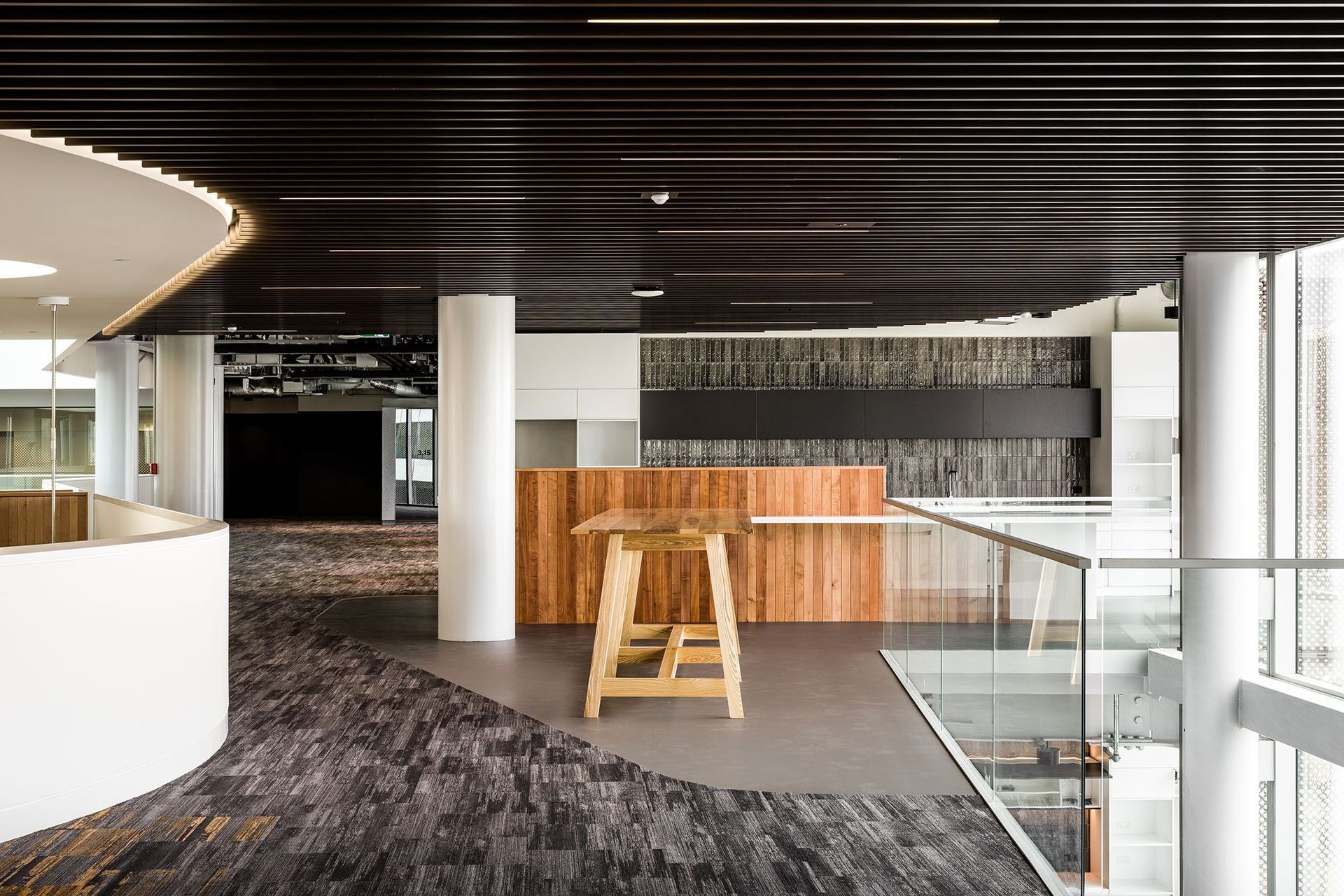 A shared kitchen on one of the floors incorporates a more residential palette of timber panelling and subway tiles to make the office space more warm and inviting.