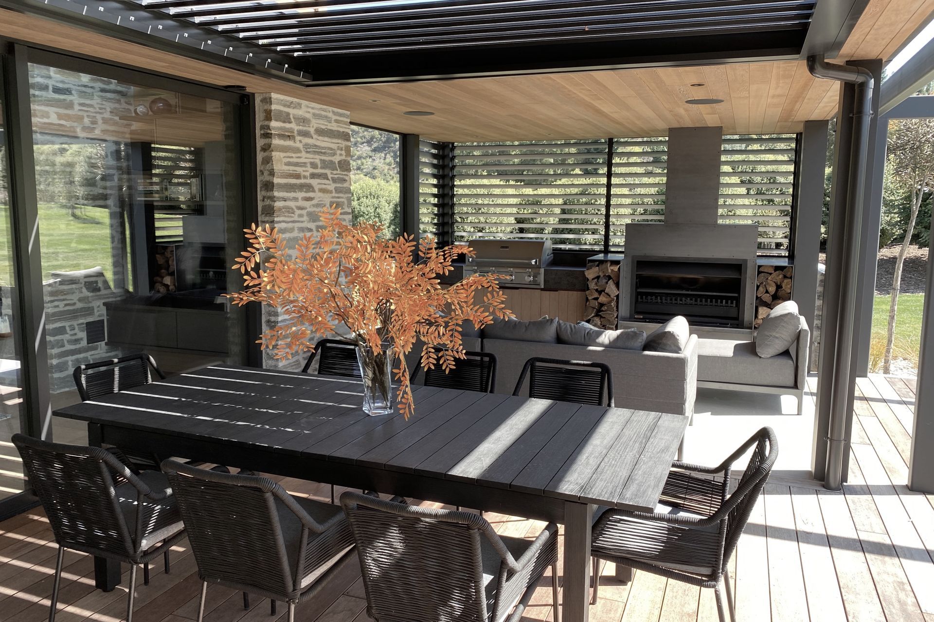 Motorised LOCARNO RL200 louvres overhead and manually adjustable RL130 louvre screens create a sheltered outdoor space  
