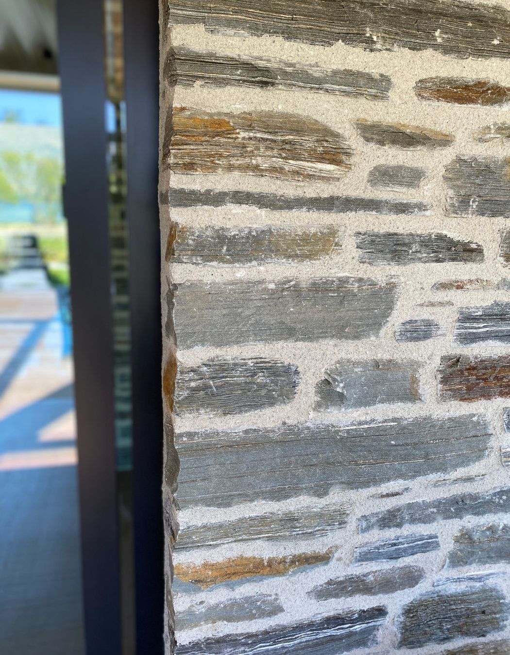 The Matte Flaxpod finish on the joinery and louvres works with natural warmth of schist 