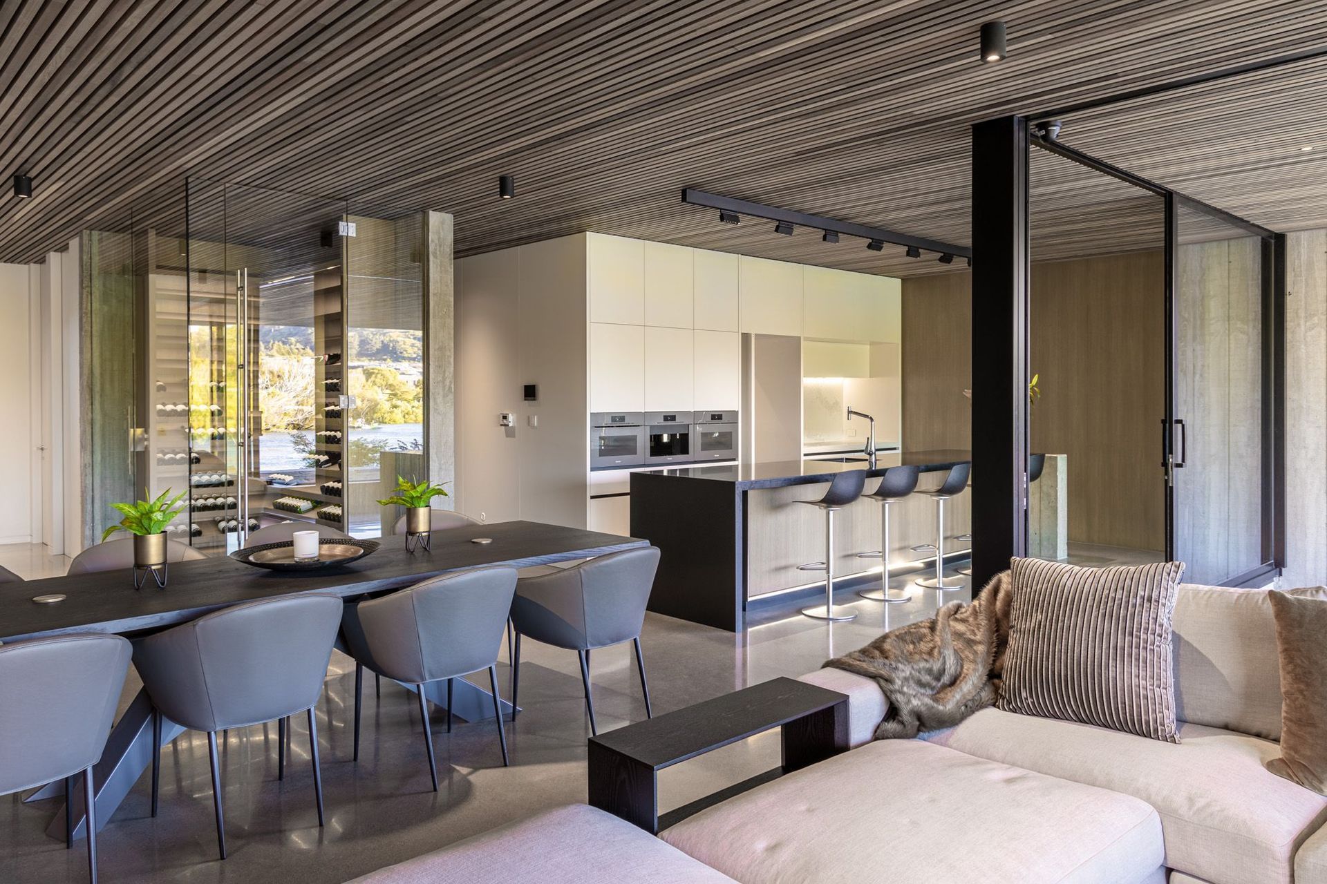 The L-shaped open-plan kitchen, living and dining area opens up into the outdoor room via large sliding doors.