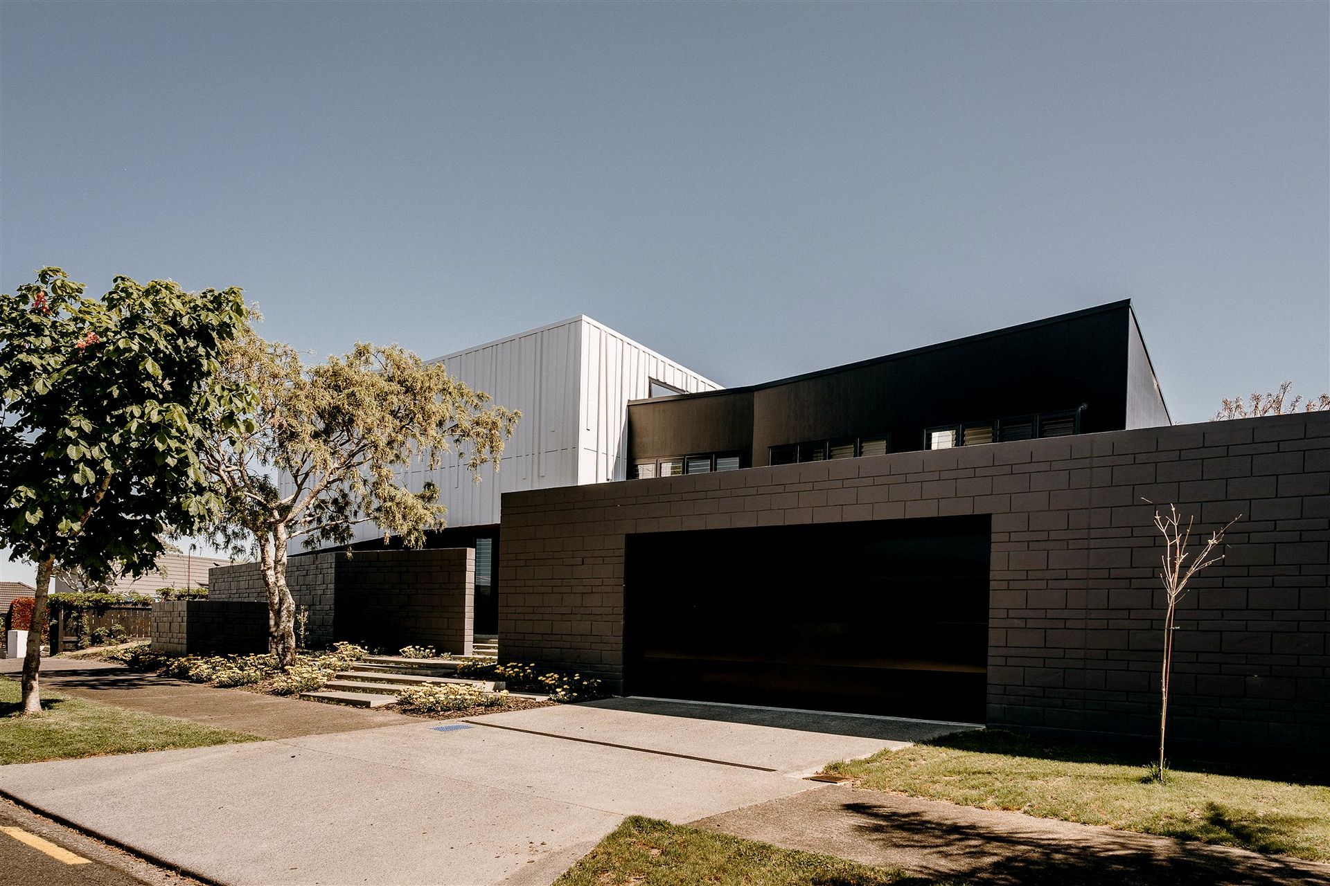Block walls that front the garage extend out to the west to create a semi-private entrance area.