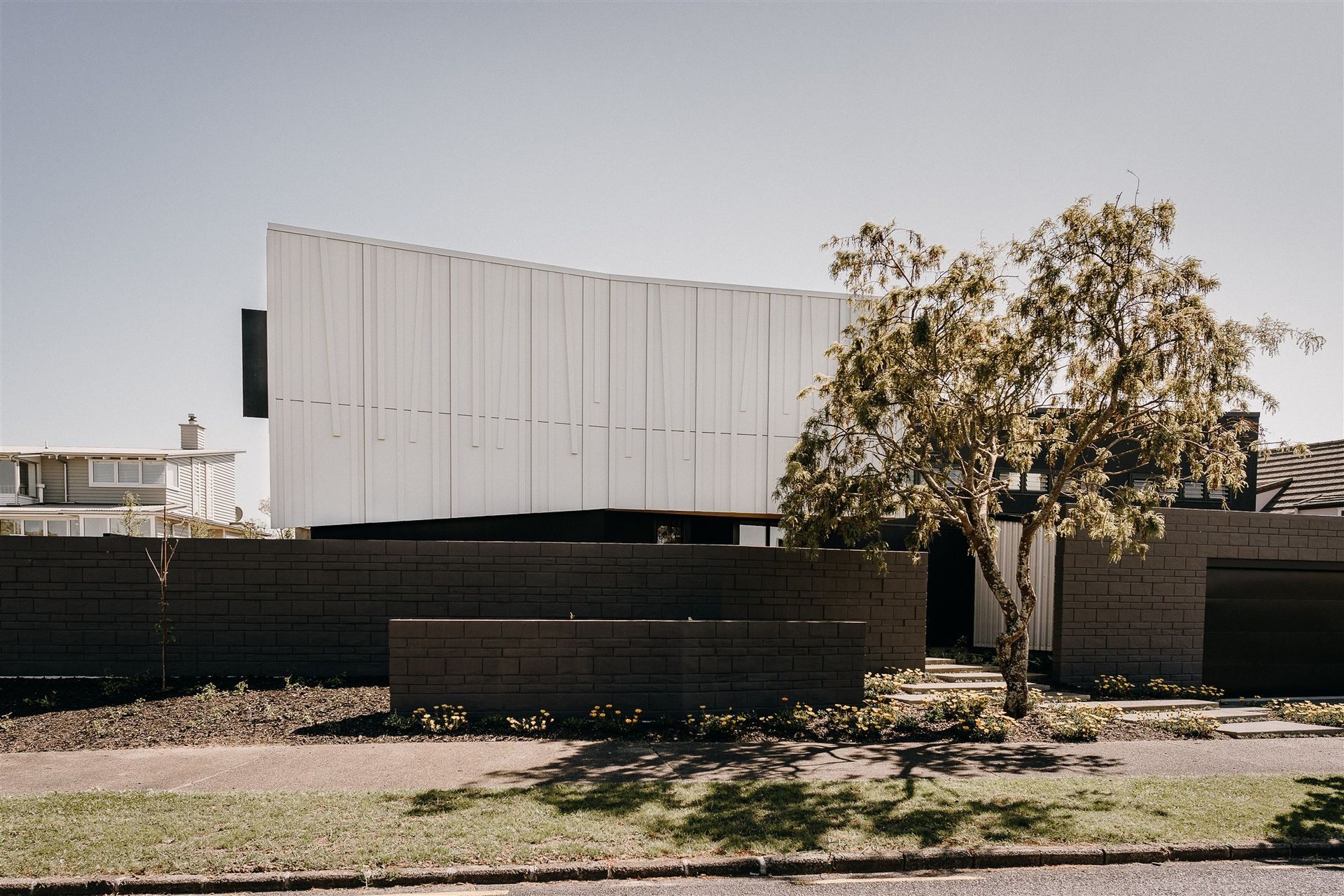 The form of the house follows the slight curve of the site while the ridgeline is angled to accentuate the slight undulations of the land. 