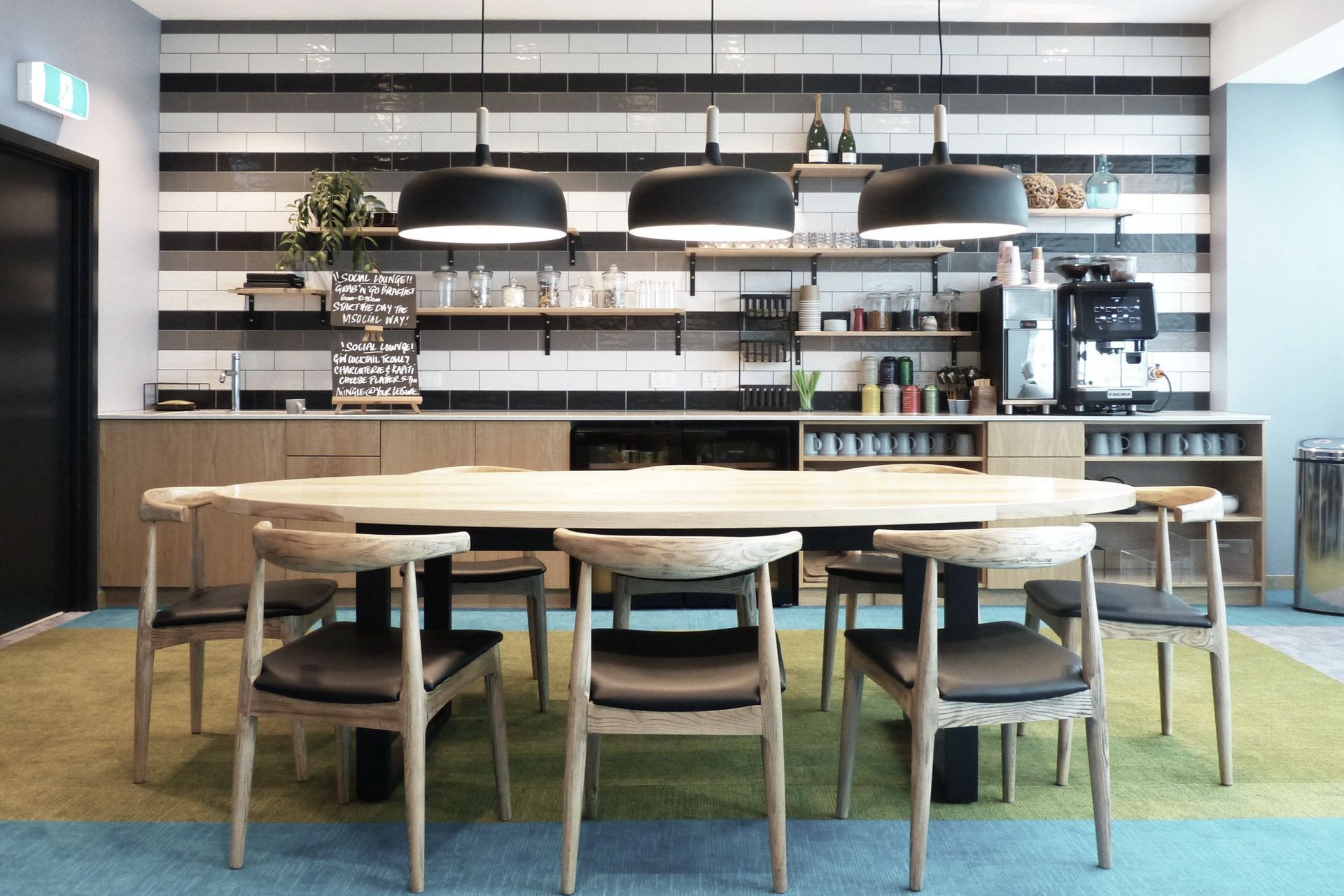 Ash and Californian oak timber finishes make durable and warm surfaces for the kitchen end of the lounge where guests can help themselves to coffee and quick meals. Ceramic subway tiles and exposed shelves make the kitchenette accessible and open.