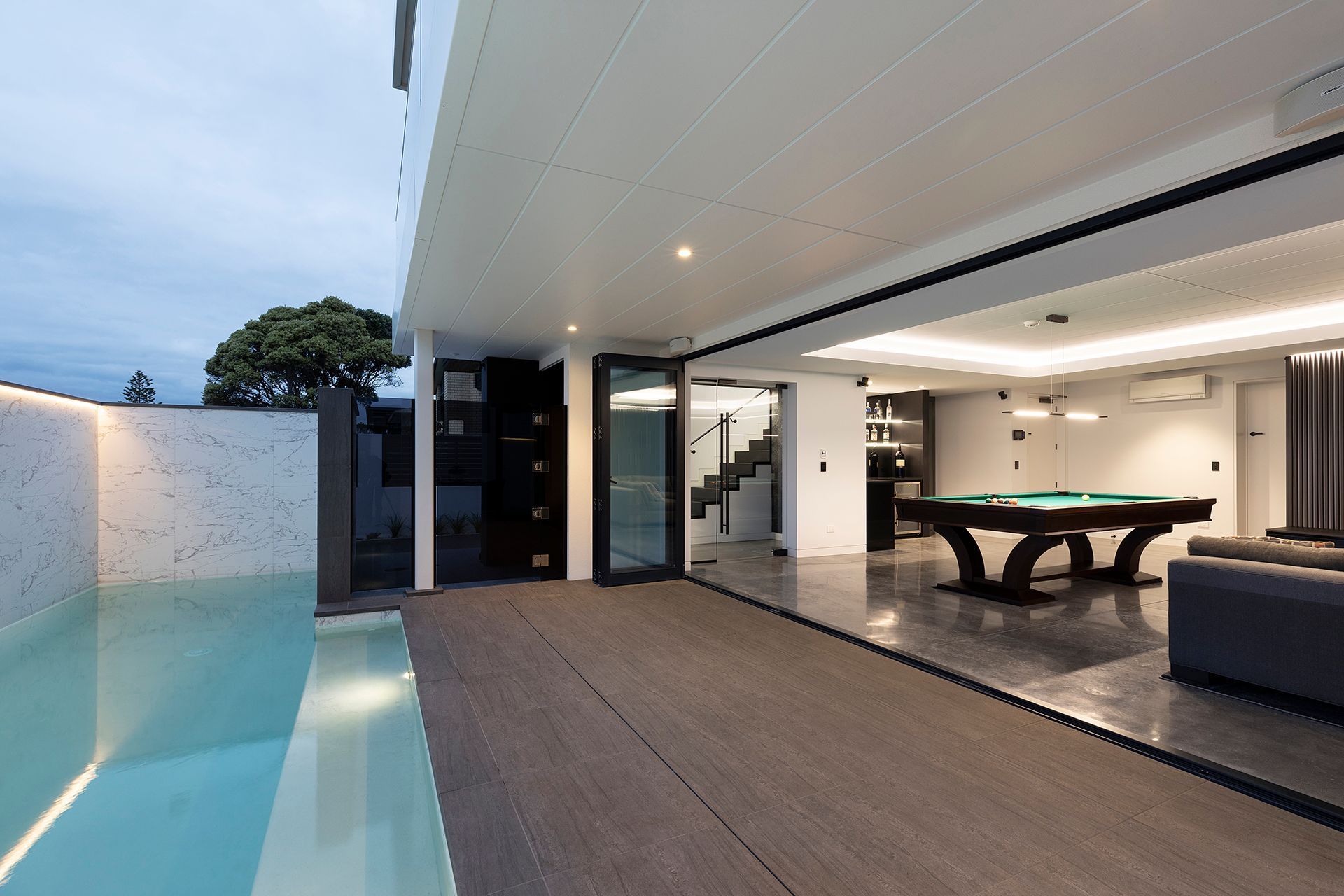 The ground floor entertainment space opens to an outdoor area fully tiled with outdoor heaters and a heated lap pool.