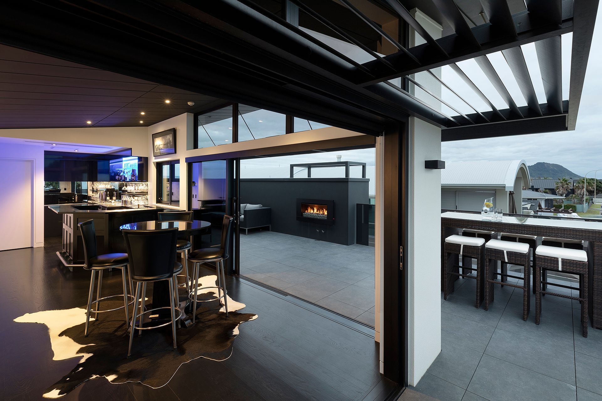 On the top level of the home an entertainment zone comes to life with a bar and seating to take in the unlimited views out over the Pacific Ocean and up to the Mount summit. 