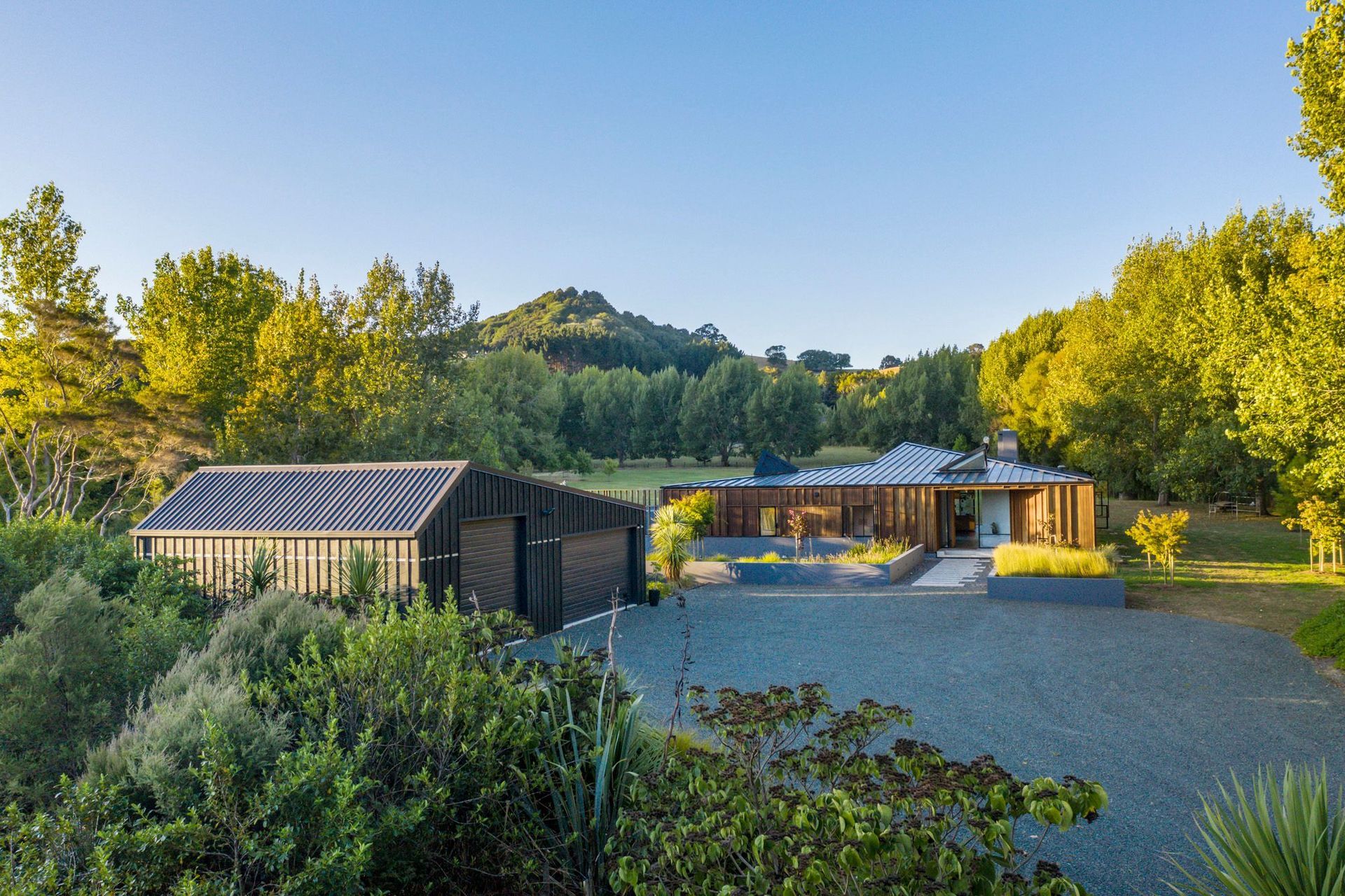 The distinctive roof angles start as soon as you arrive and park beside the garage with its asymmetrical roof, while the roof of Matakana House points towards Sugar Loaf Mountain.