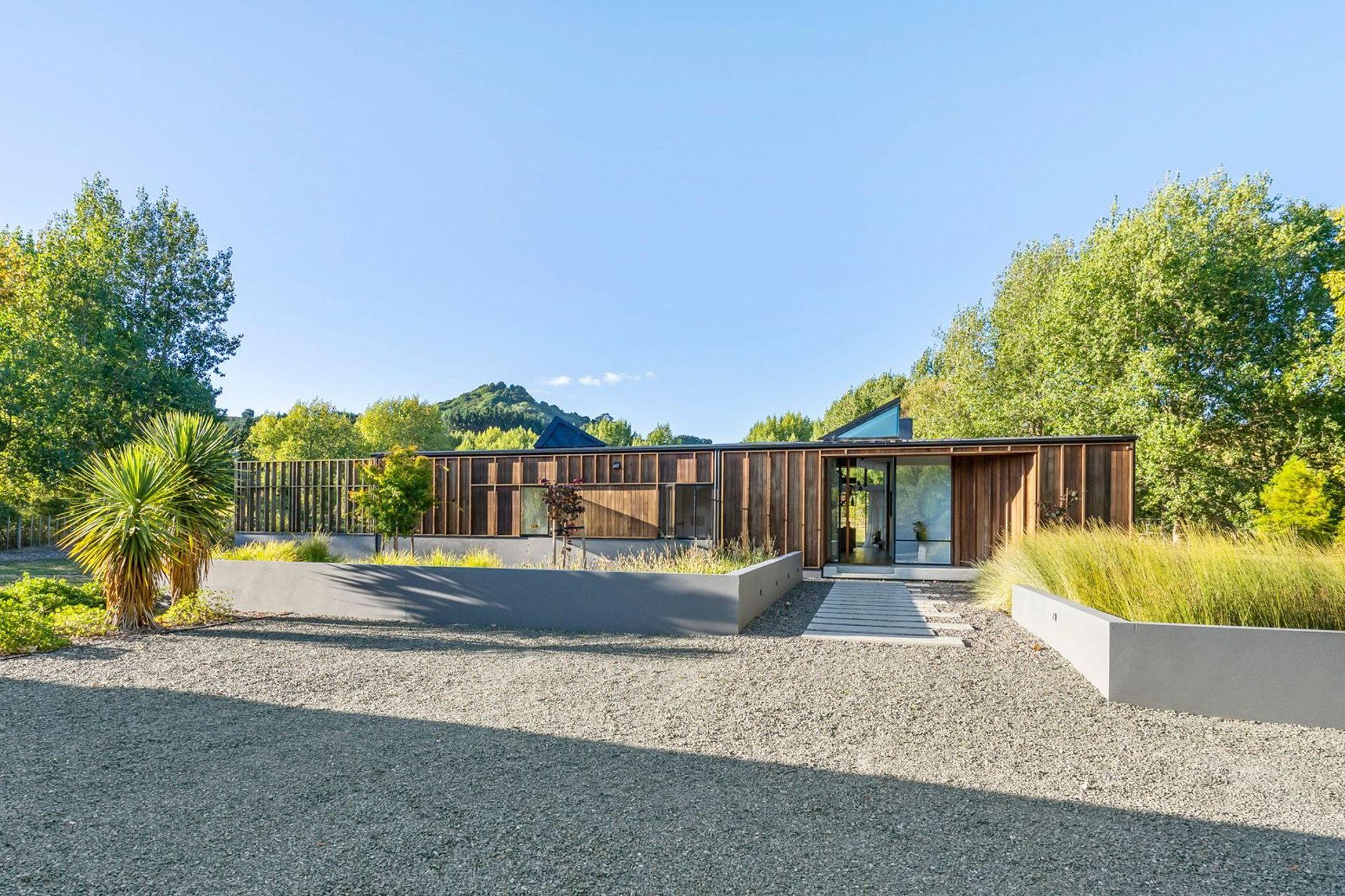 The board-and-batten, cedar-clad house sympathetically blends into its rural surroundings and a landscape planted in native plants and grasses, poplar trees and a fruit orchard.