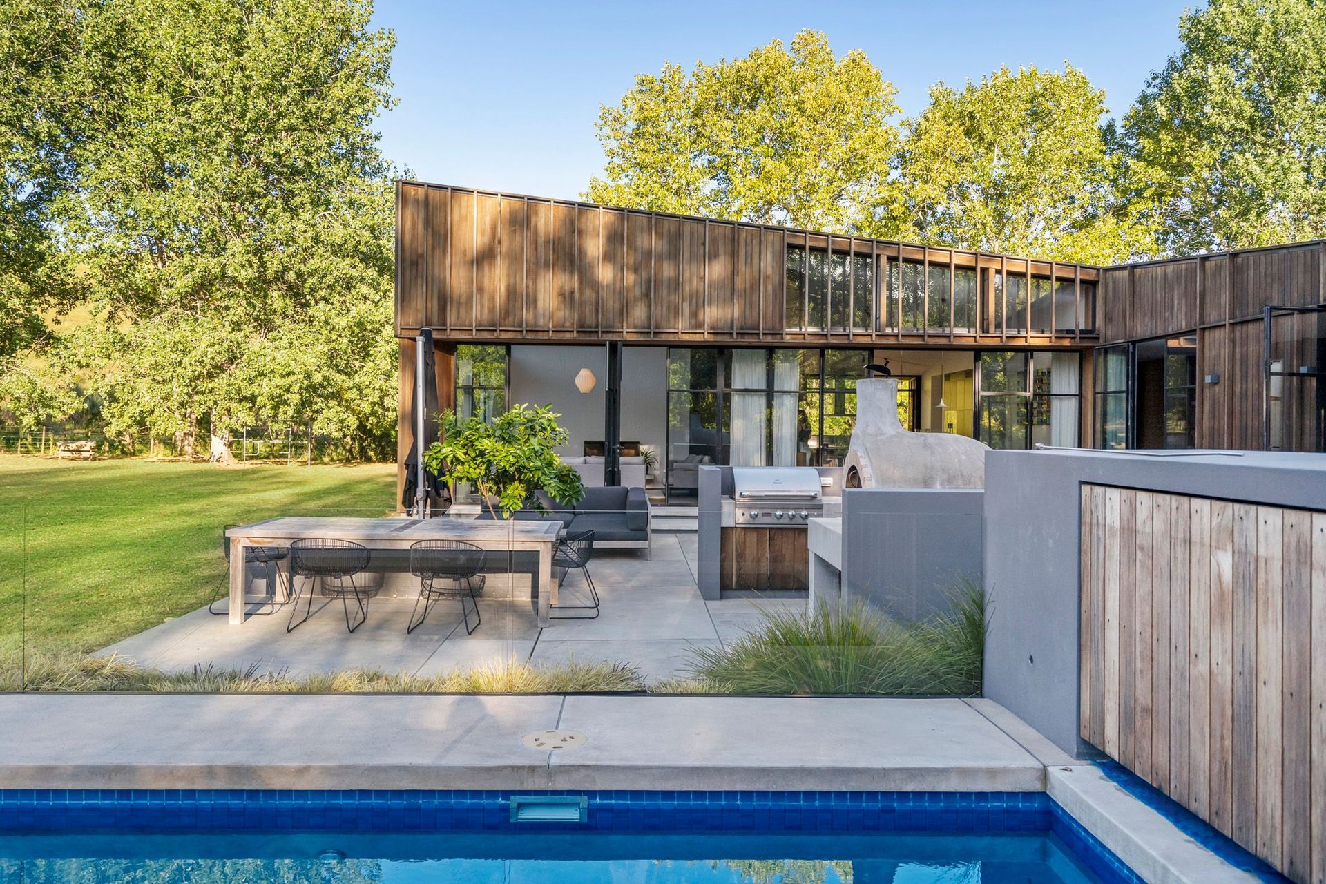 The northwestern-facing courtyard features an outdoor dining area complete with BBQ and Italian-style pizza oven.