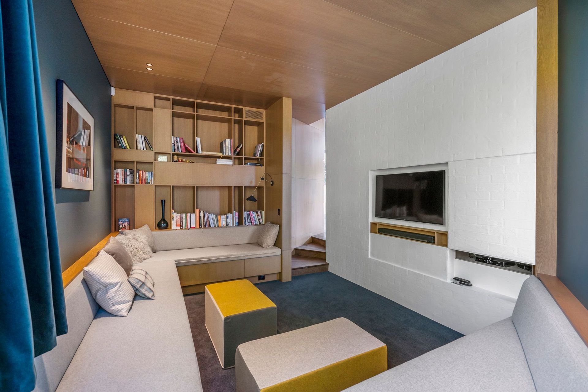The snug acts as a media room, a library and a space for the children to make dens out of the cushions from the bench-style seating that lines three walls of the space.