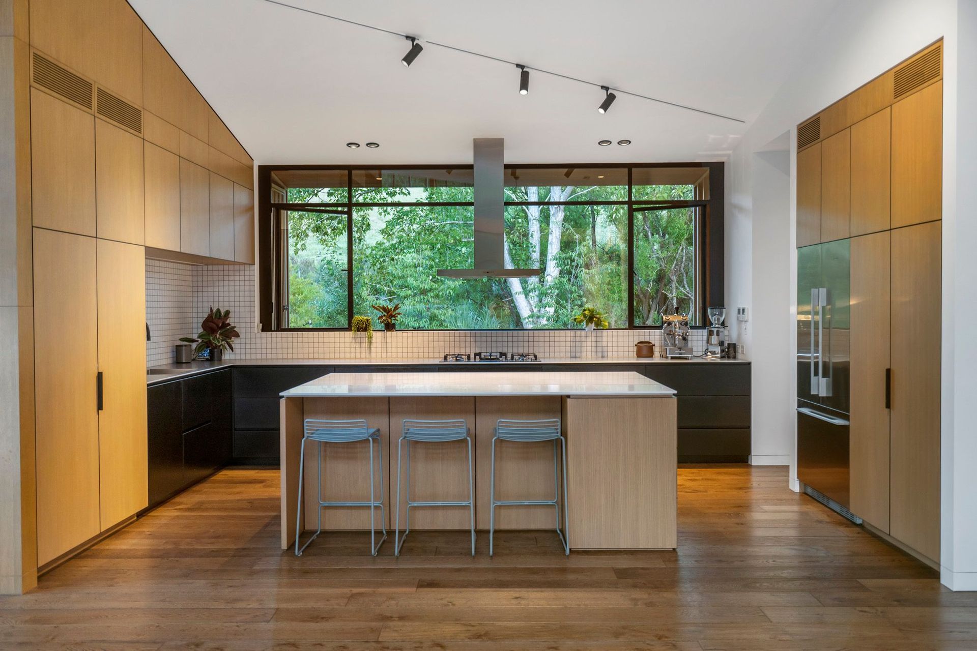 The kitchen is a chef's dream, with a stunning framed view of the trees, plenty of workspace and easy-to-clean surfaces.