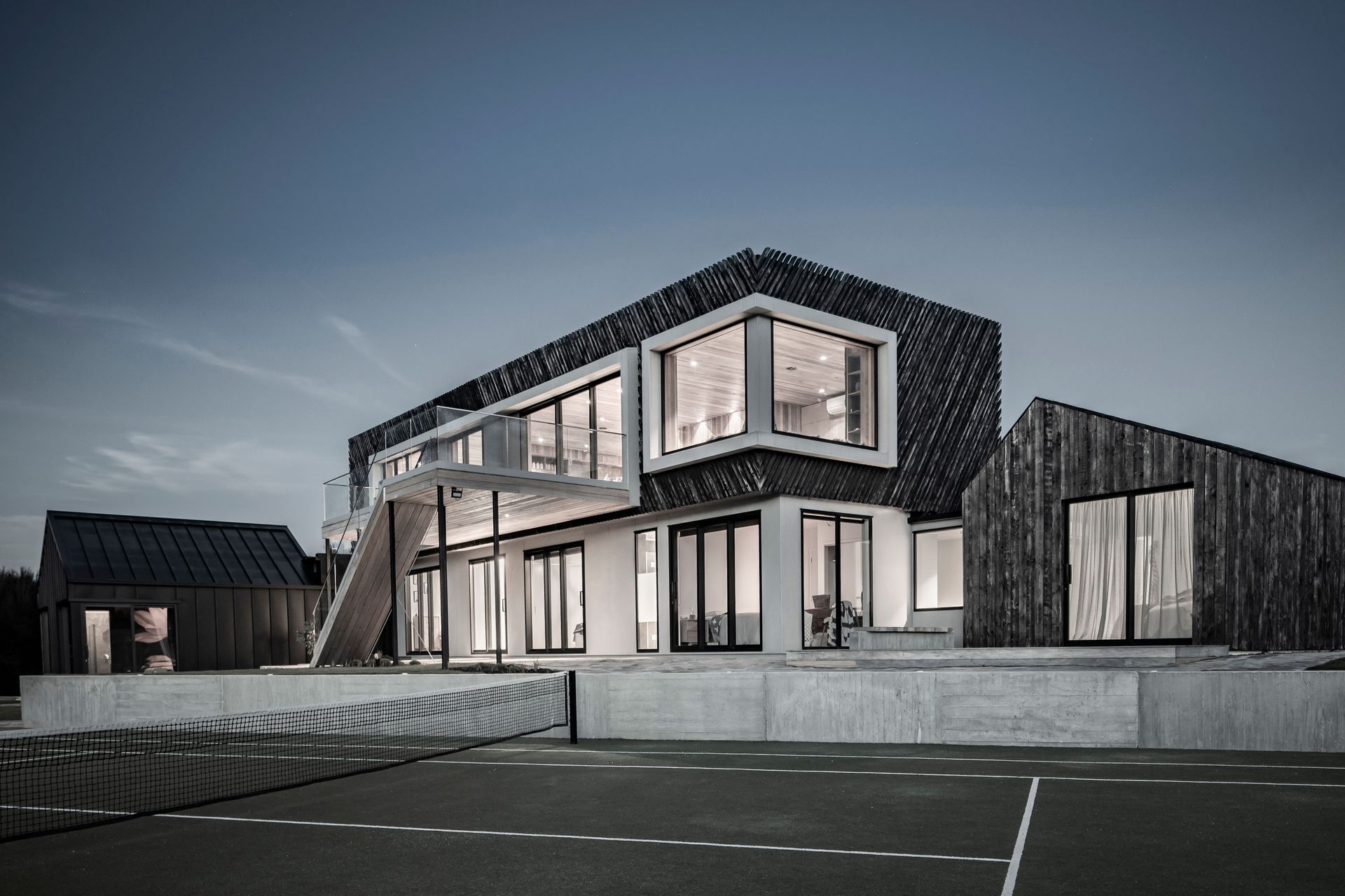 The view from the tennis court of the northern elevation with bedroom wings on either side.