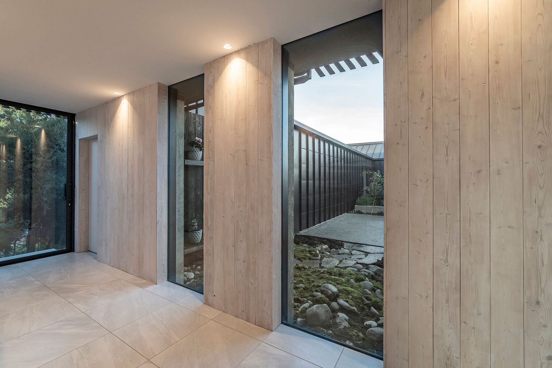 The gallery space off the hallway has a deck off the end, while glazed arches overlook a micro-landscape in the main courtyard near the entrance.