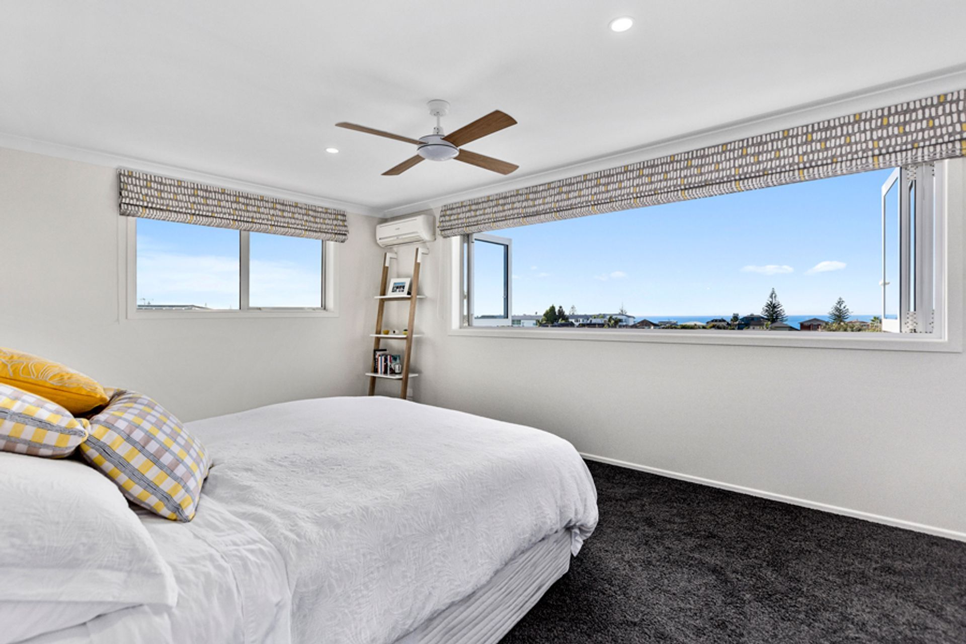 A bedroom with a stunning view of Mount Maunganui beach. 