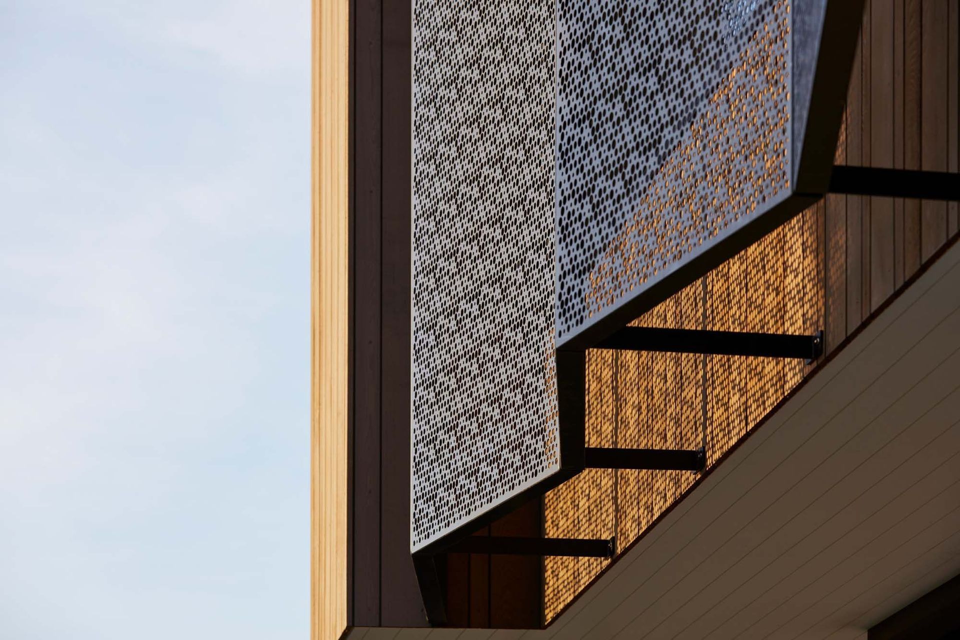 On the upper storey, fixed patterned mesh screens protect the windows at the front, facing the road, and at the rear, facing the park – offering privacy and shading.