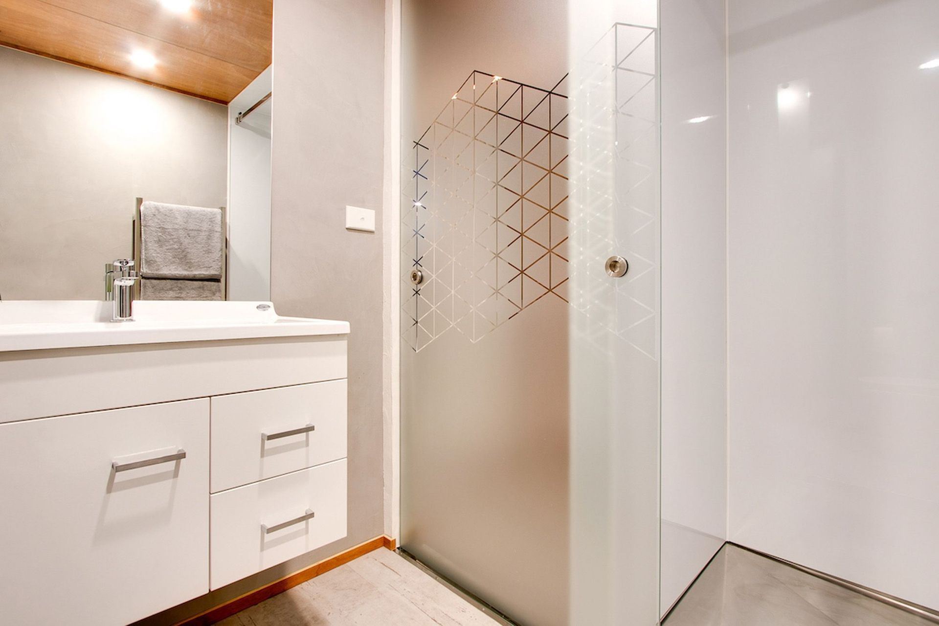 A geometric pattern is a feature on the shower door and window.