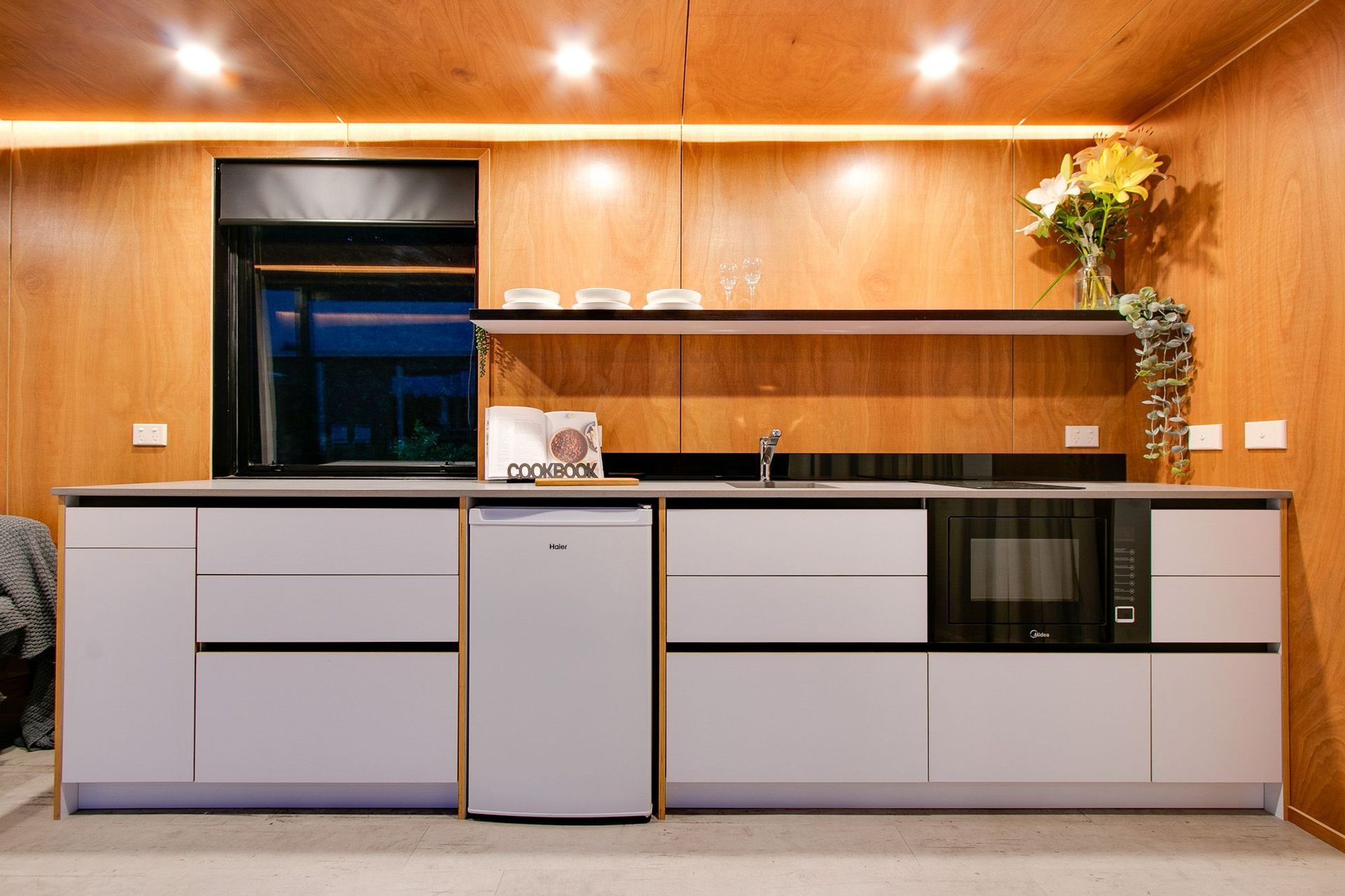 Plywood lines the walls and ceiling, combined with a white kitchen, ensures a minimal look.