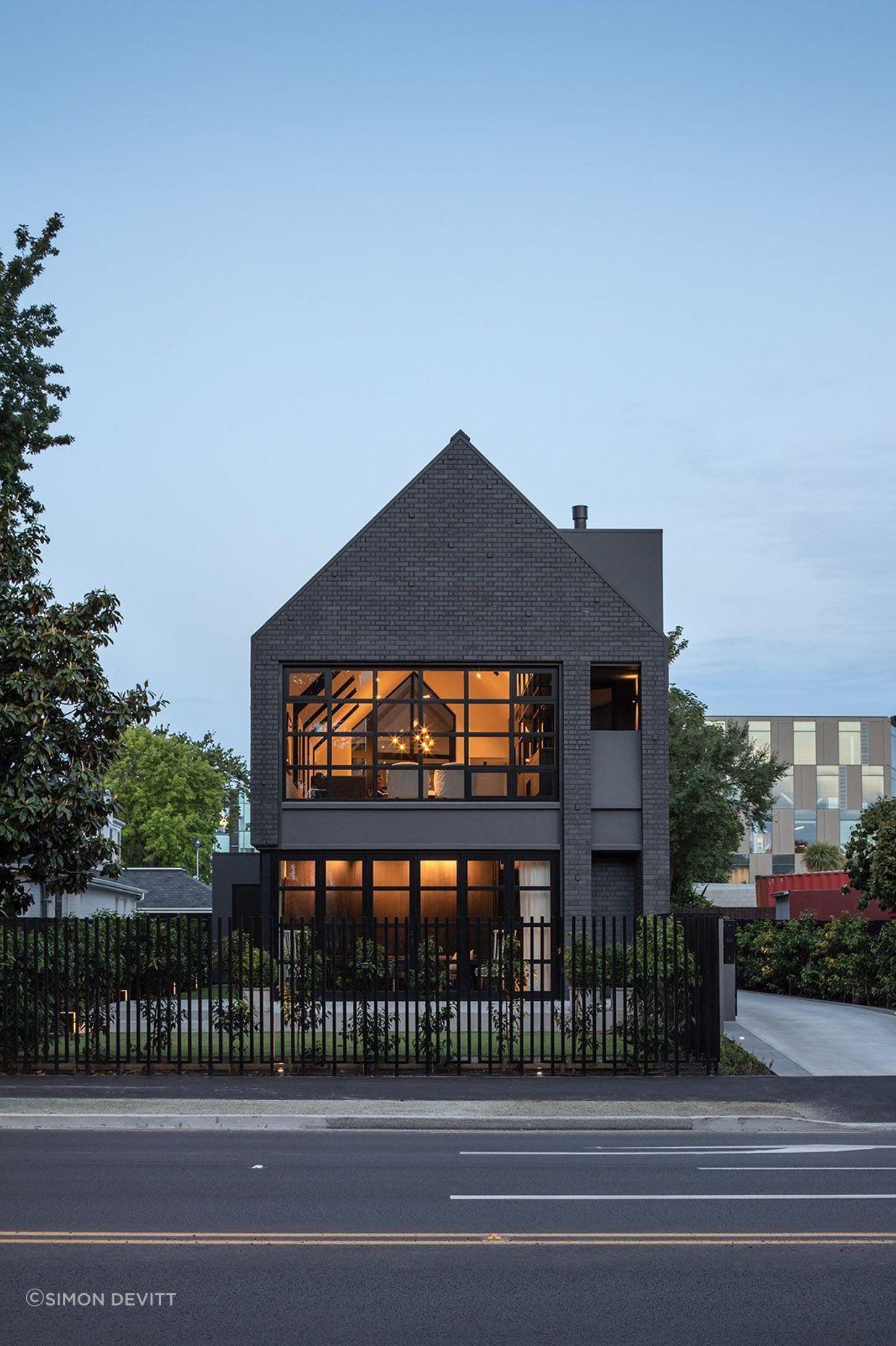 In the front garden, a simple paved patio looks directly across to the willows of Hagley Park.