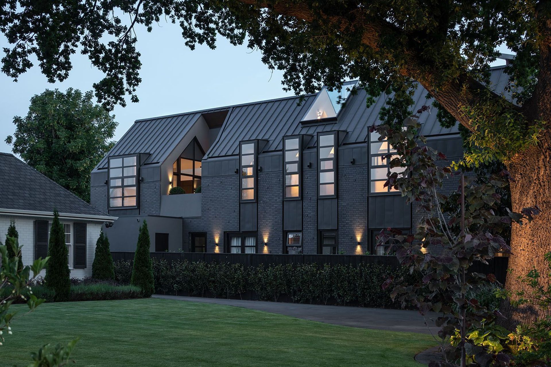 Under the cloak of darkness, the home is lofty and light, its interiors turning outwards, floating weightlessly atop a shrouded form. A courtyard is carved out of the gabled form, separating the open-plan area from the intimate areas of the upper level, 