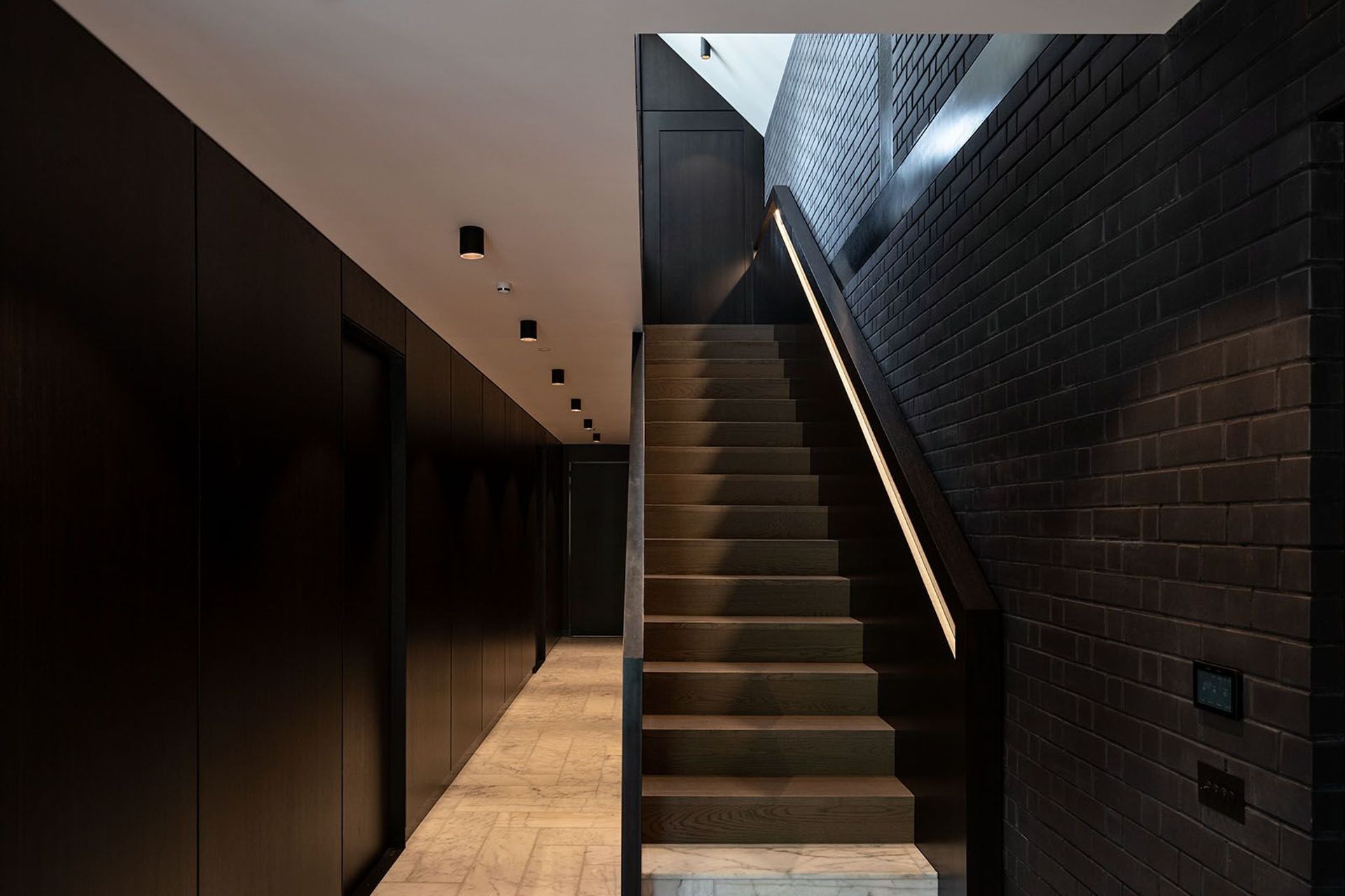 This corridor acts as the spine of the home - a spacious area that gives little away aside from an offering of texture and juxtaposition of colour.