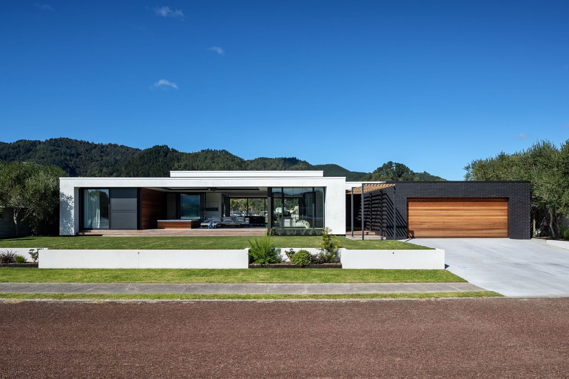 The view from the street shows the clean lines of the pavilion form with its contrasting materials defining the house from the garage.