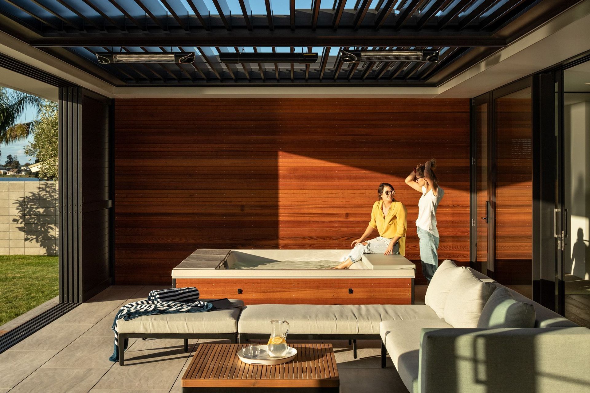 The outdoor room features a spa pool and a roof that opens up to the elements.
