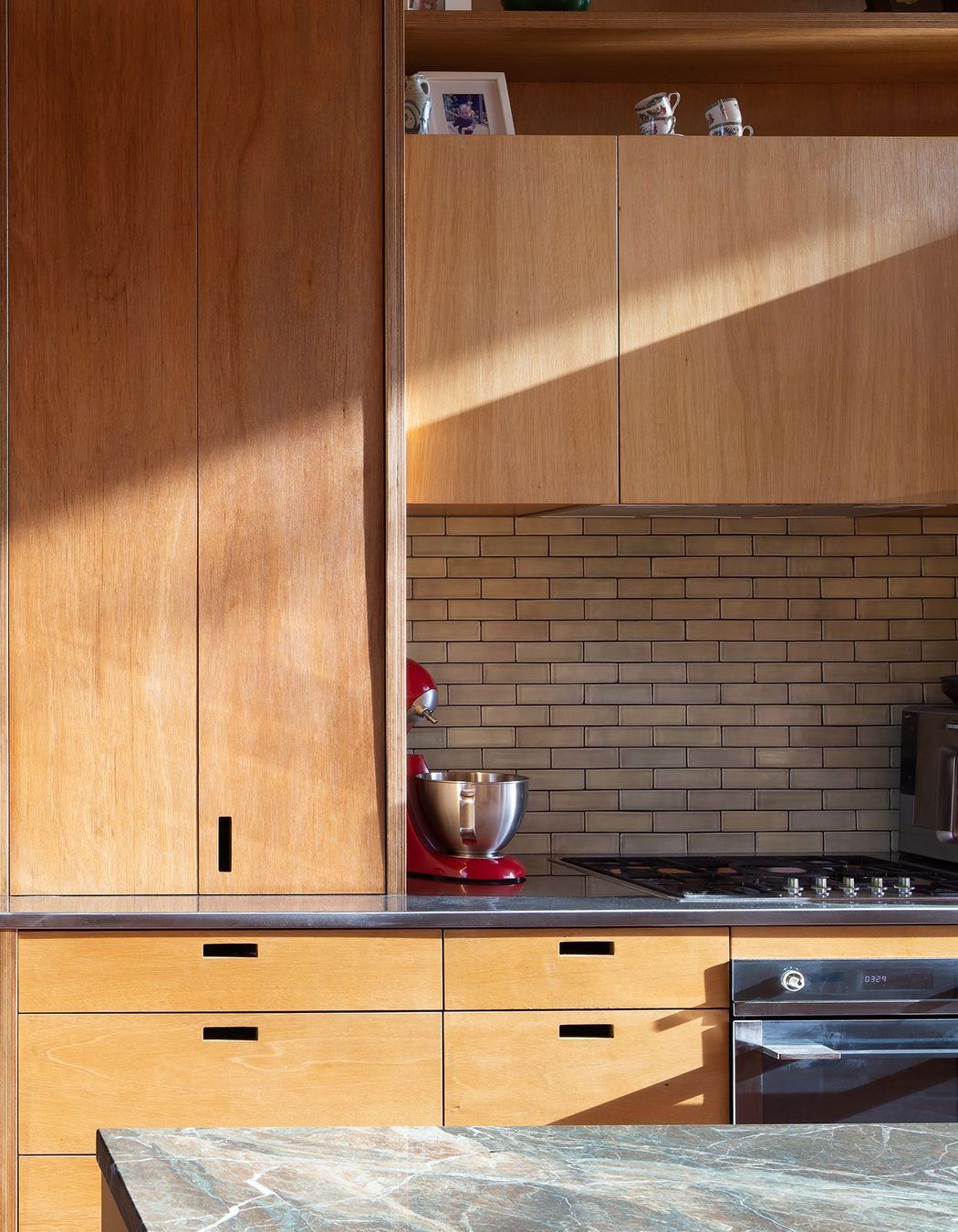 A close-up of the kitchen reveals the bespoke locally built plywood cabinetry.