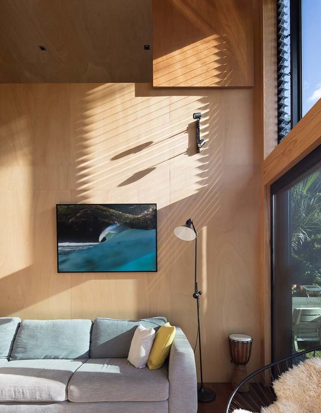 Mid-to-late afternoon sun provides warmth and light due to the large window areas.<br />Framed Piha wave photograph by Craig Levers.