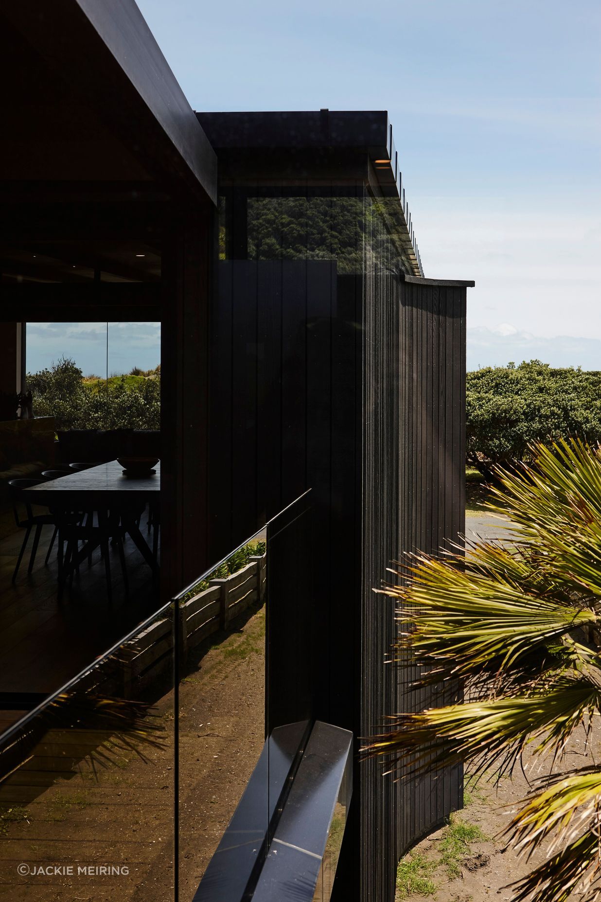 With living areas confined to the first floor, outdoor spaces read like niches within the building's envelope. Floor-to-ceiling glazing facilitates clear sightlines to the view beyond.