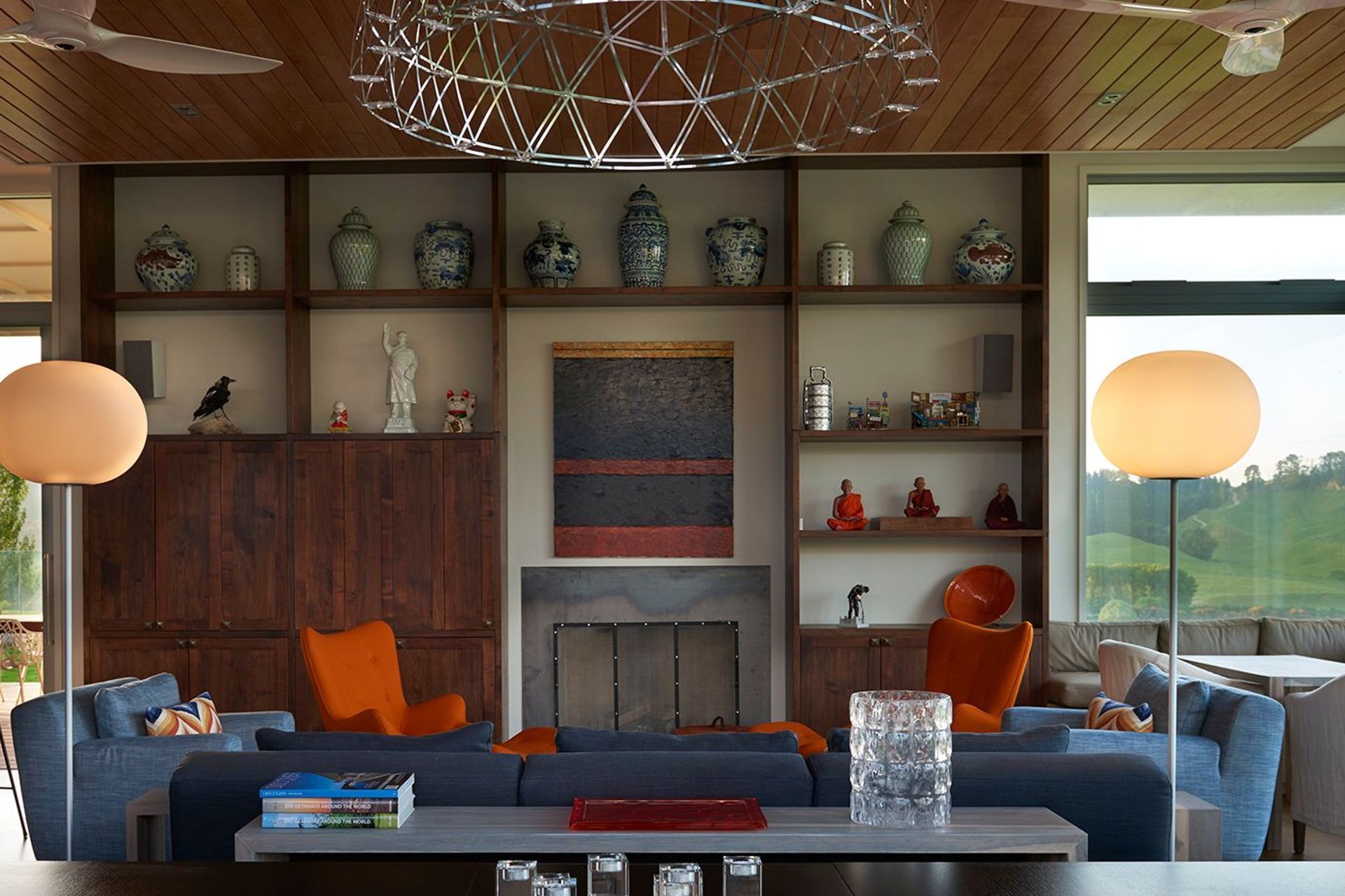 Built-in acacia cabinetry features the owner's collection of Asian vases and objects, along with a painting by JS Parker above the fireplace.