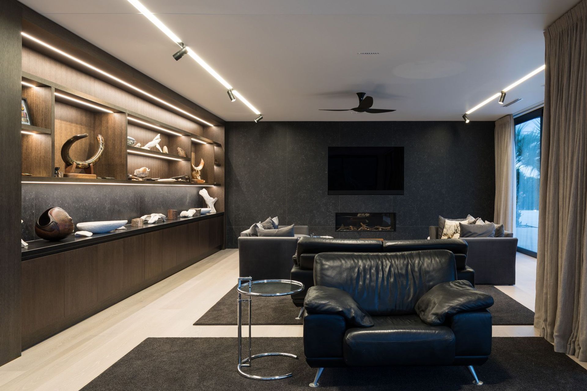 The lounge enjoys cosy fireside seating and views out over Houhora Harbour. LED strip lights add a touch of drama to the ceiling and cabinetry in the evening.