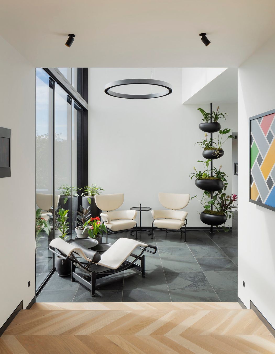 A double height glazed volume with a bridge above serves as a reading room with views across the outdoor spaces and into the living and dining areas.