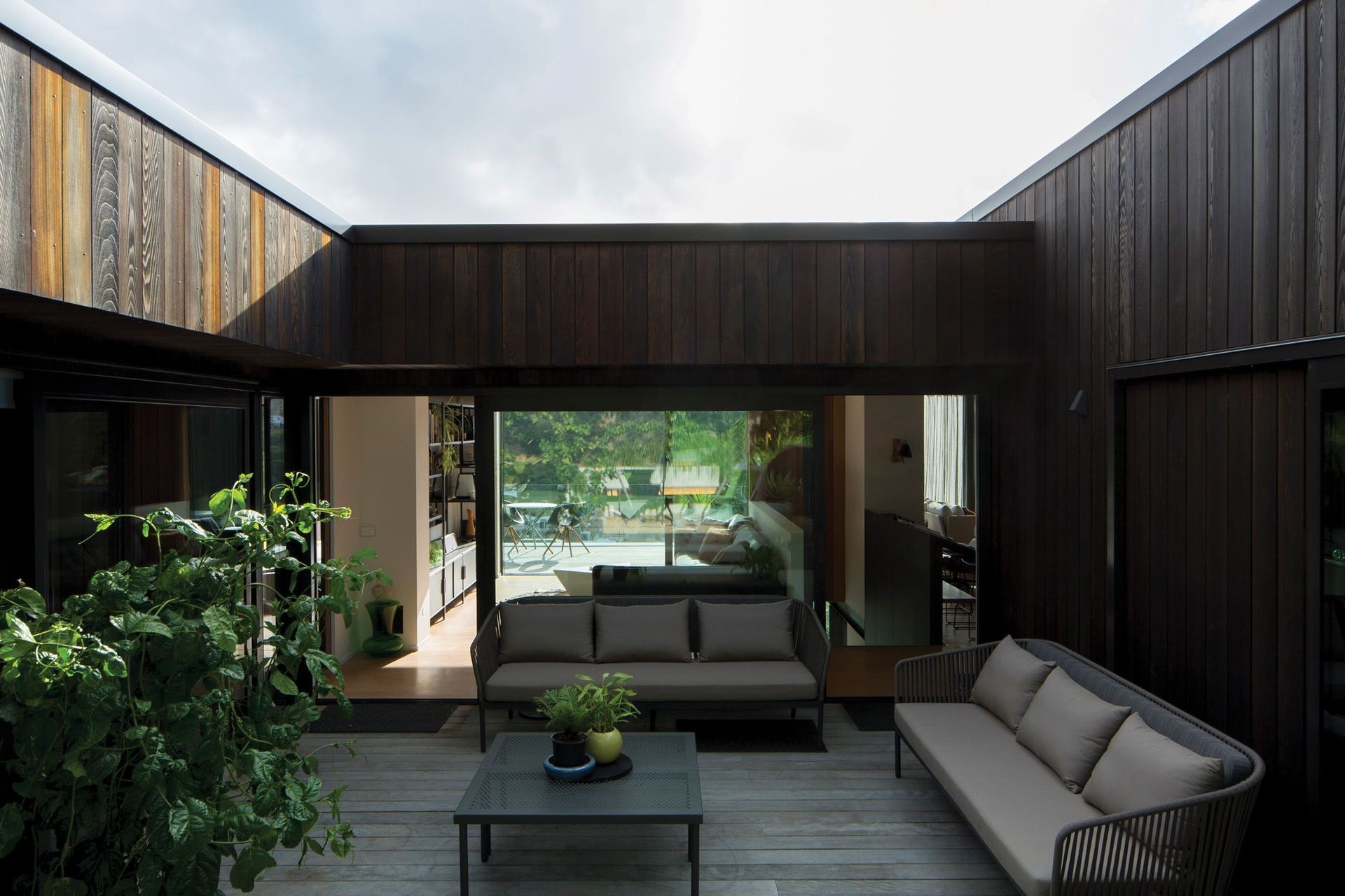 The south-facing central courtyard space is connected to the snug and the view, with the guest bedroom suite through sliding doors to the right.