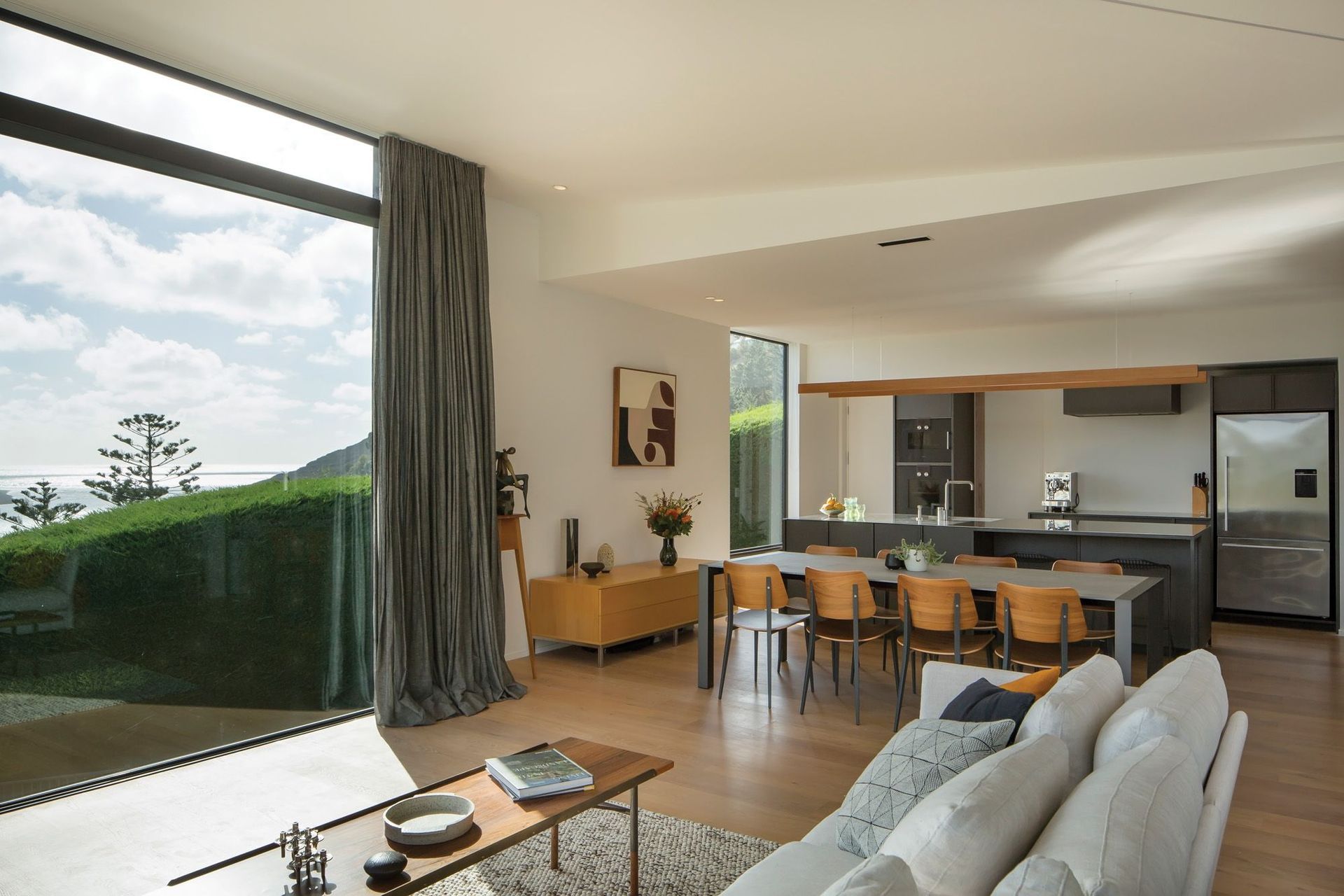 The open-plan kitchen, dining and lounge area enjoys panoramic views of the ocean and leads out onto a deck area.