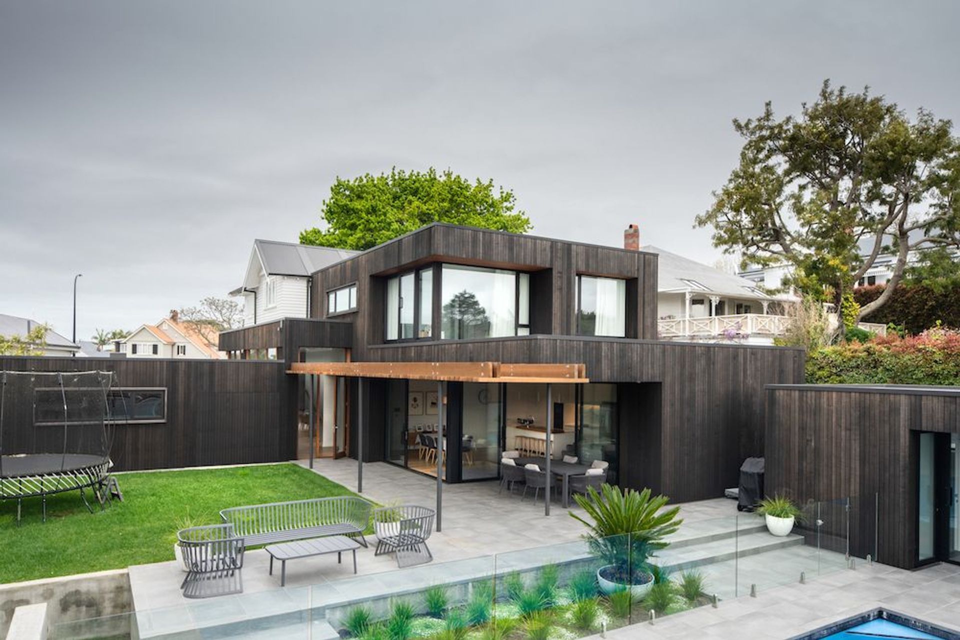 The addition to this bungalow is in the form of five 'boxes' clad in dark, vertical cedar that wrap around and connect with the horizontal weatherboards of the original home. 