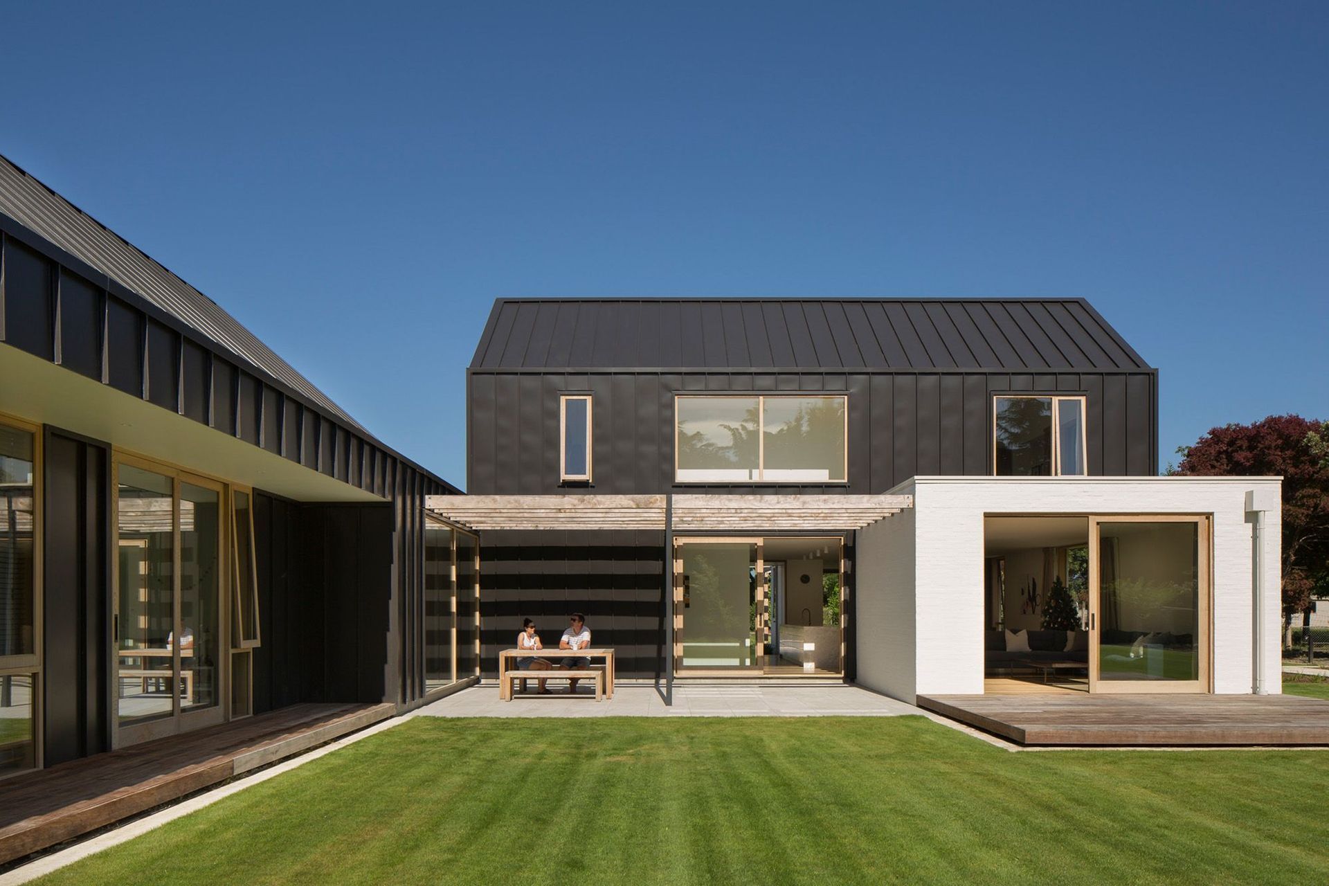 Natural light and shade is carefully controlled throughout this home. Here, a recessive courtyard with a pergola provides shade and shelter from the sun and wind.